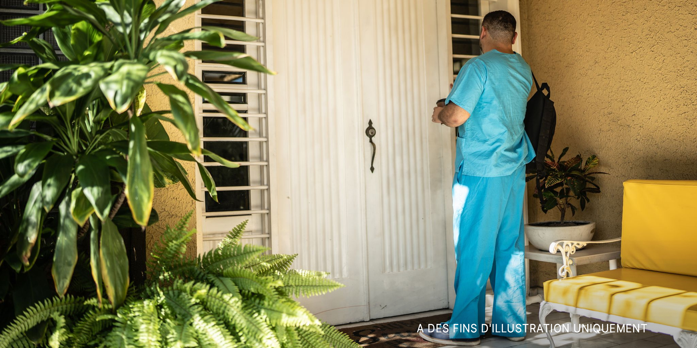 Un homme en blouse attendant à la porte d'entrée | Source : Getty Images