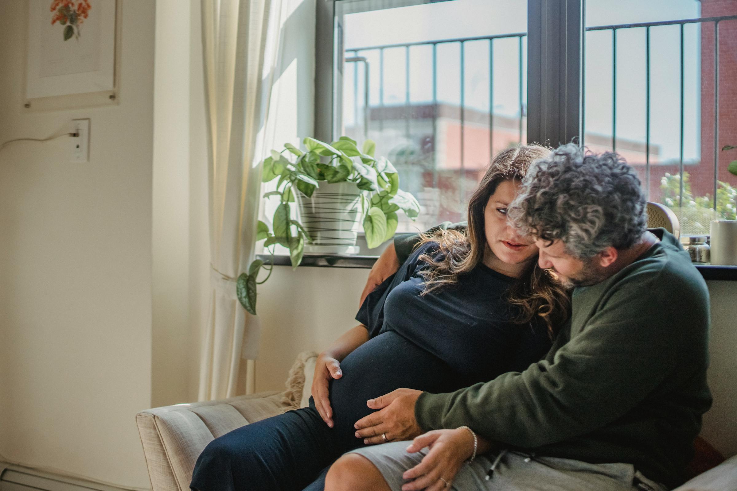 Un couple, dont la femme est enceinte, assis ensemble | Source : Pexels