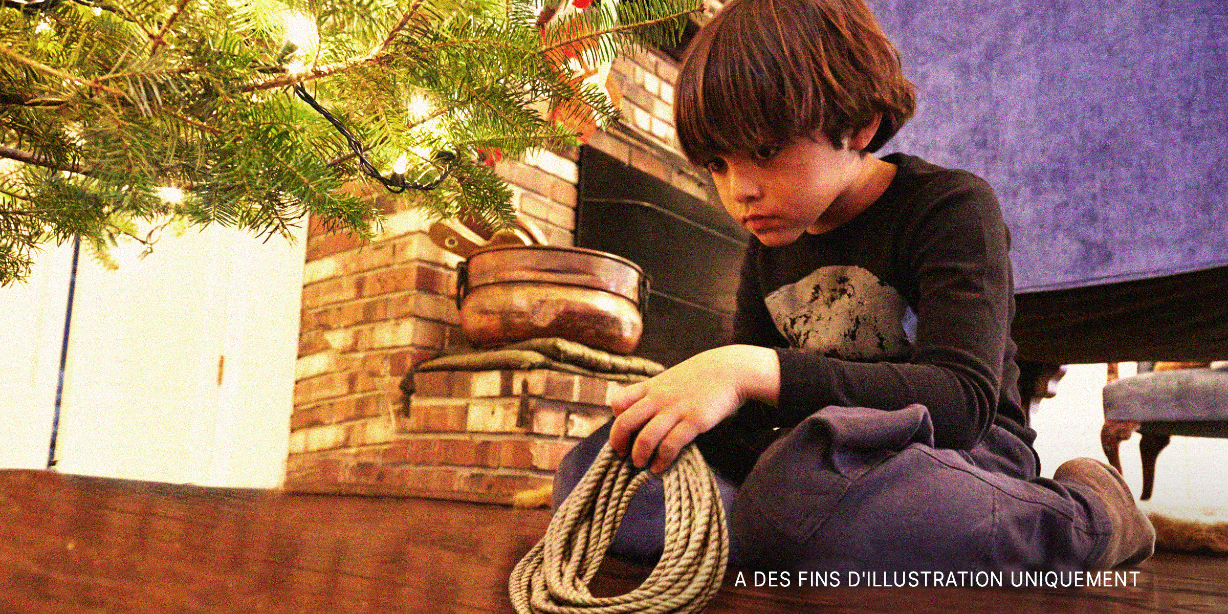 Garçon avec une corde sous un arbre de Noël | Source : Getty Images