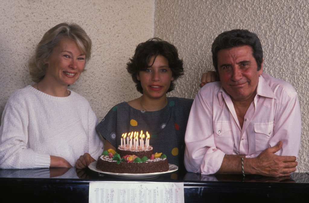Gilbert Bécaud chez lui avec sa femme et sa fille en mai 1988 à Paris, France. | Photo : Getty Images