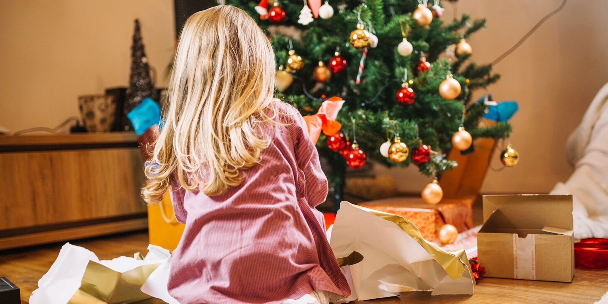 Une fille ouvre des cadeaux de Noël | Source : FreePik