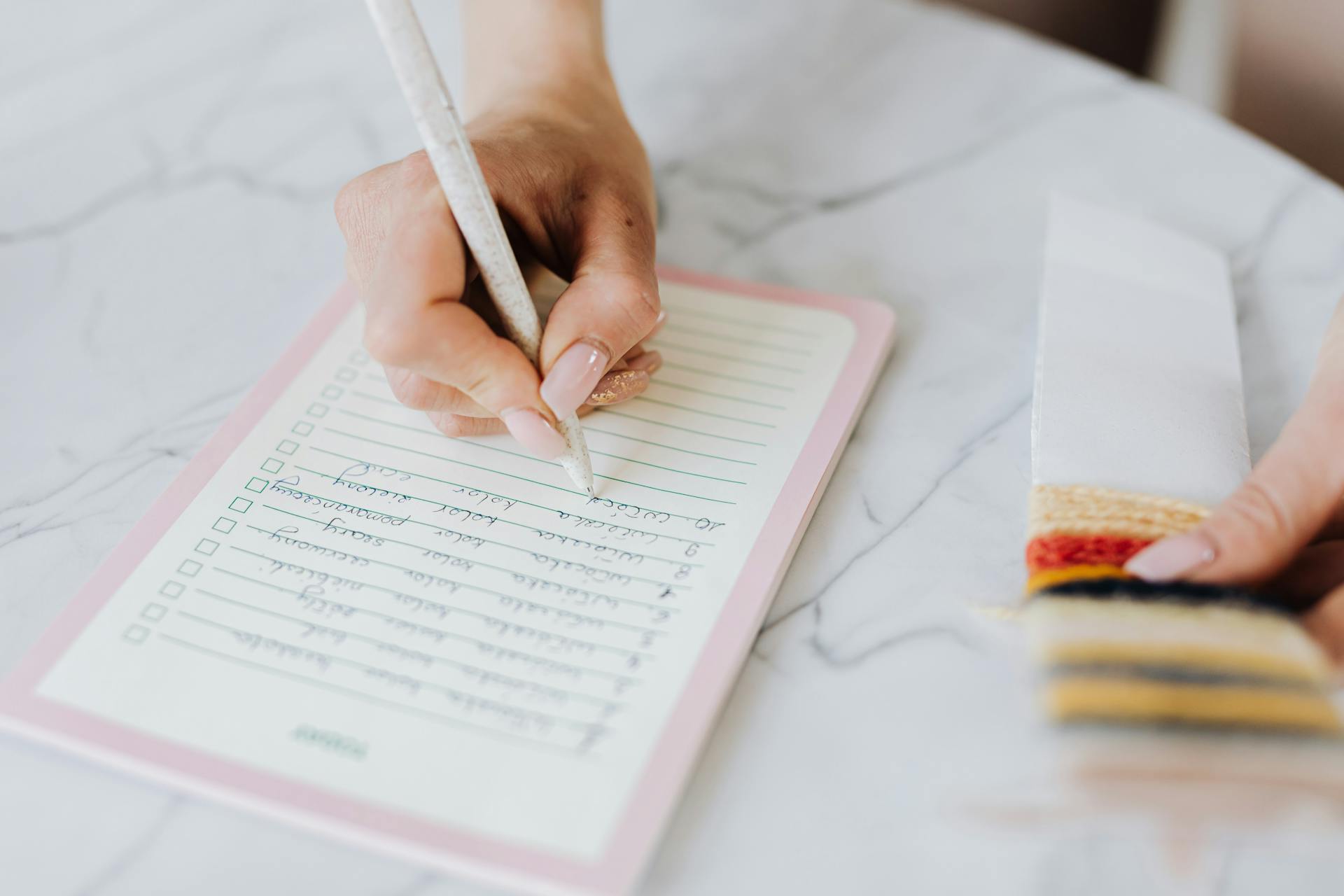 Une femme qui écrit dans un bloc-notes | Source : Pexels