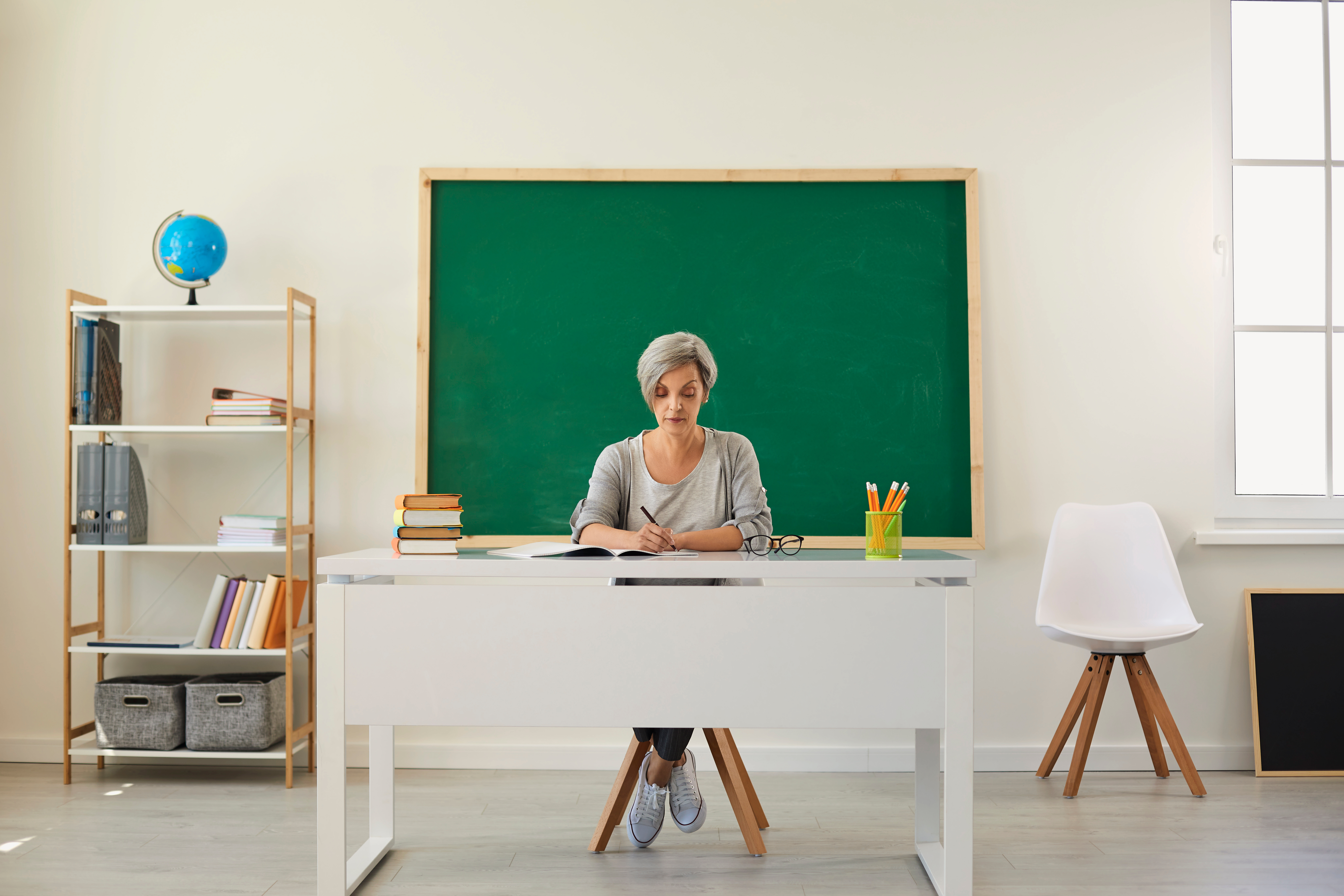 Enseignante dans une salle de classe vide | Source : Shutterstock