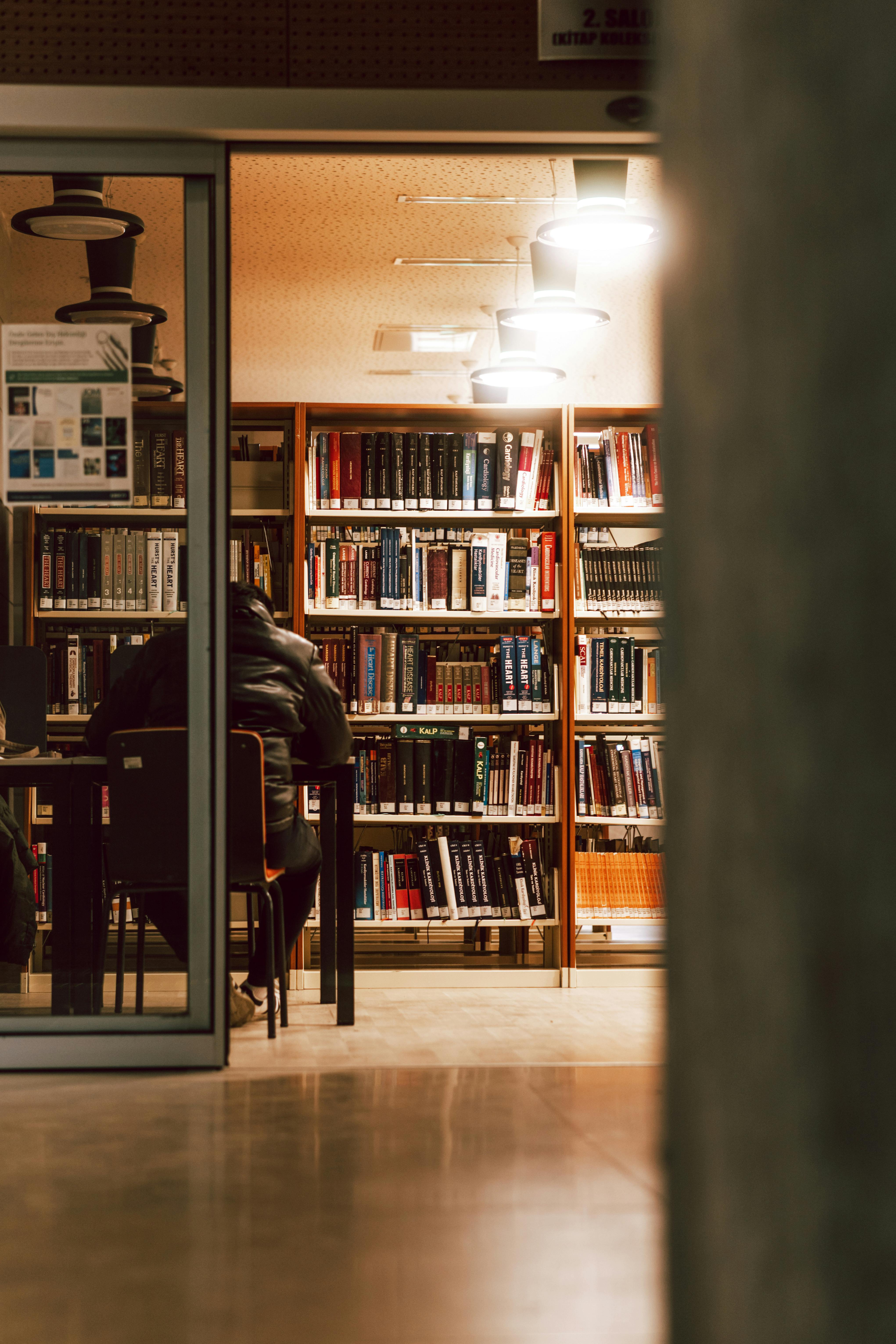 Un homme assis dans une librairie | Source : Pexels