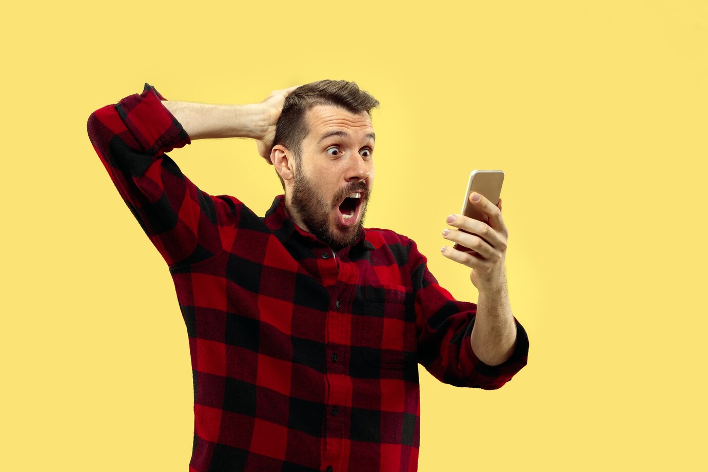 Un homme excité qui regarde son téléphone | Source : Freepik