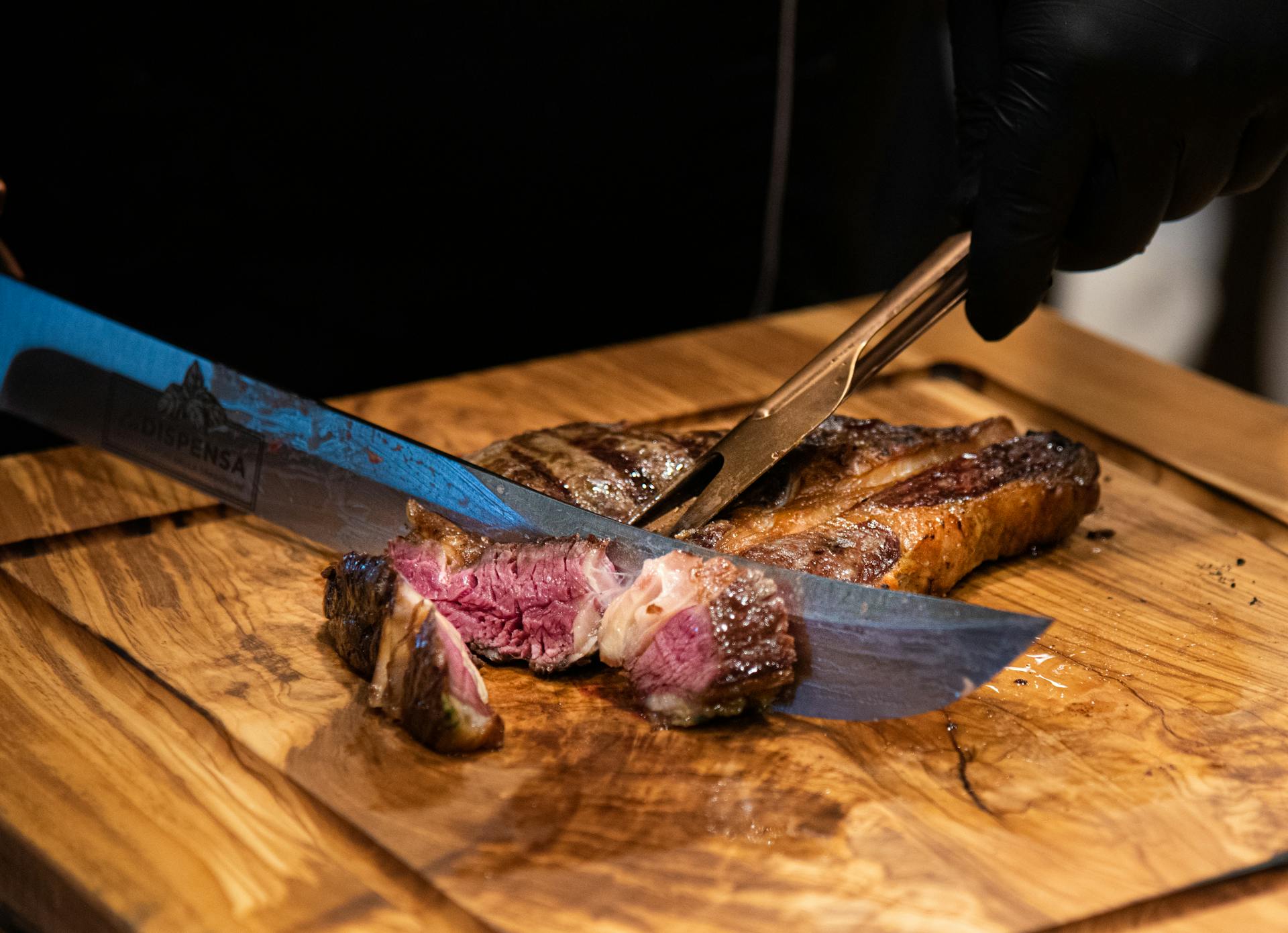 Un homme en train de couper un steak | Source : Pexels