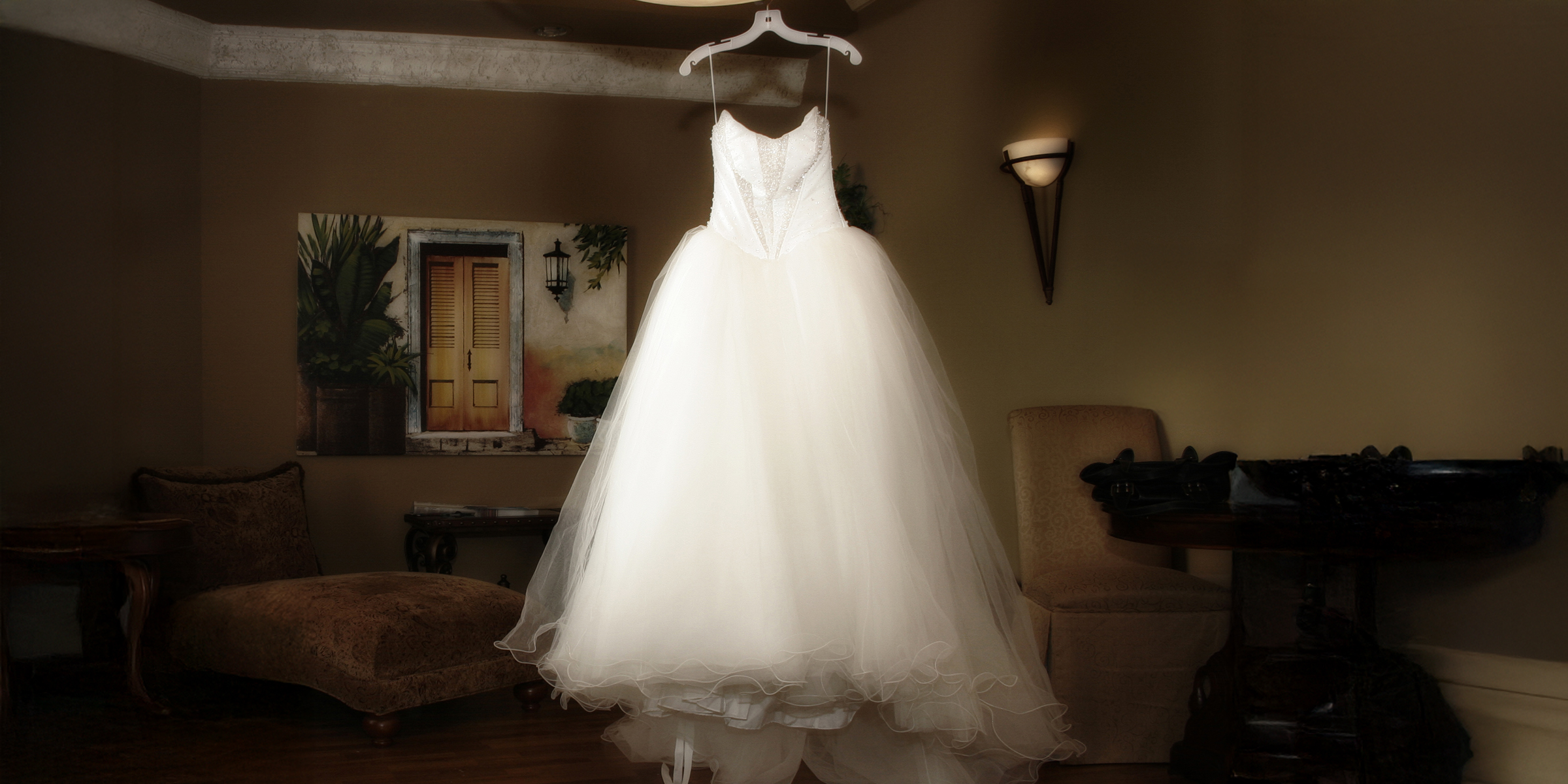 Une élégante robe de mariée blanche suspendue à un cintre | Source : Shutterstock
