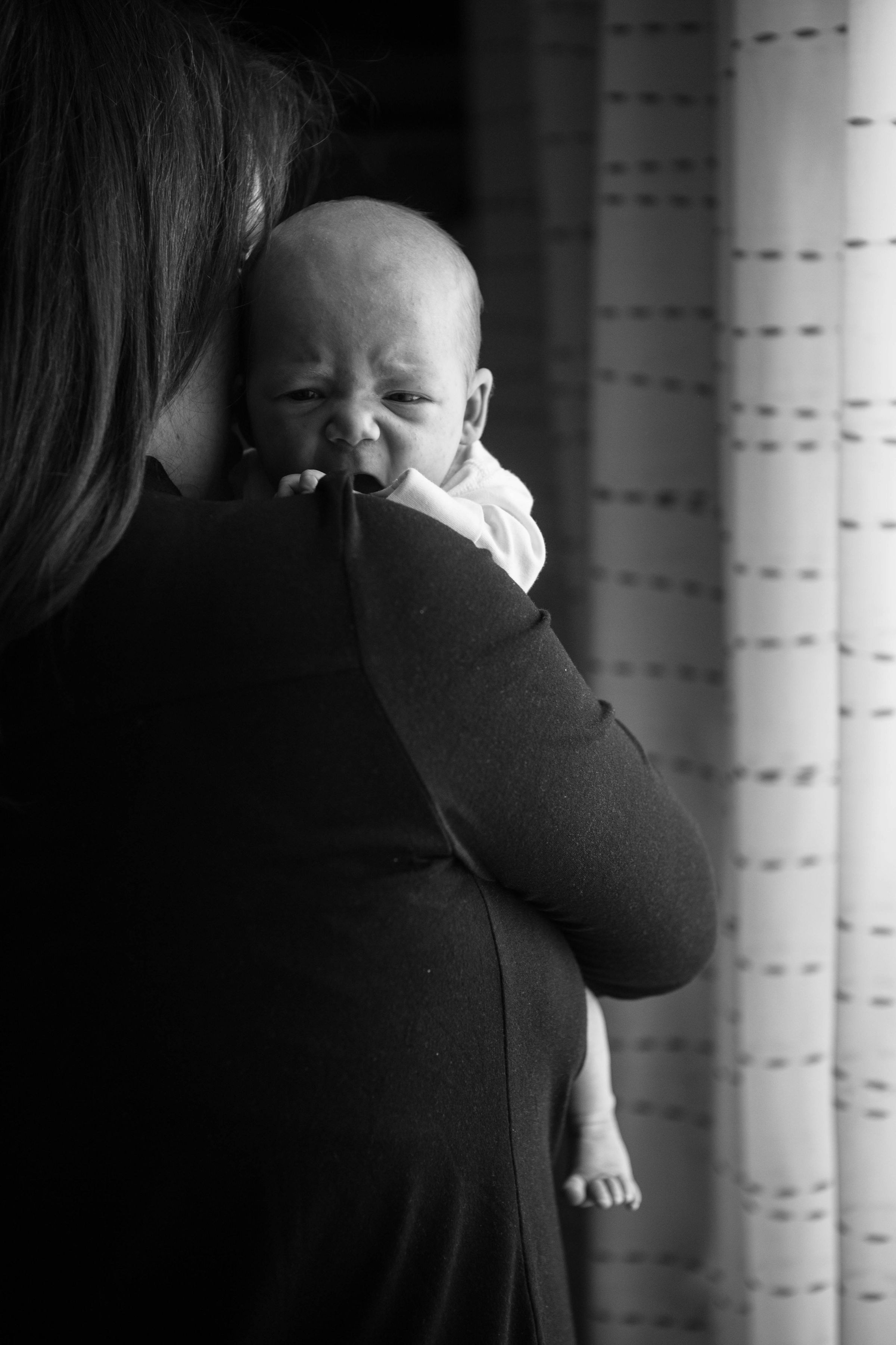 Gros plan d'une femme tenant un bébé en pleurs | Source : Unsplash