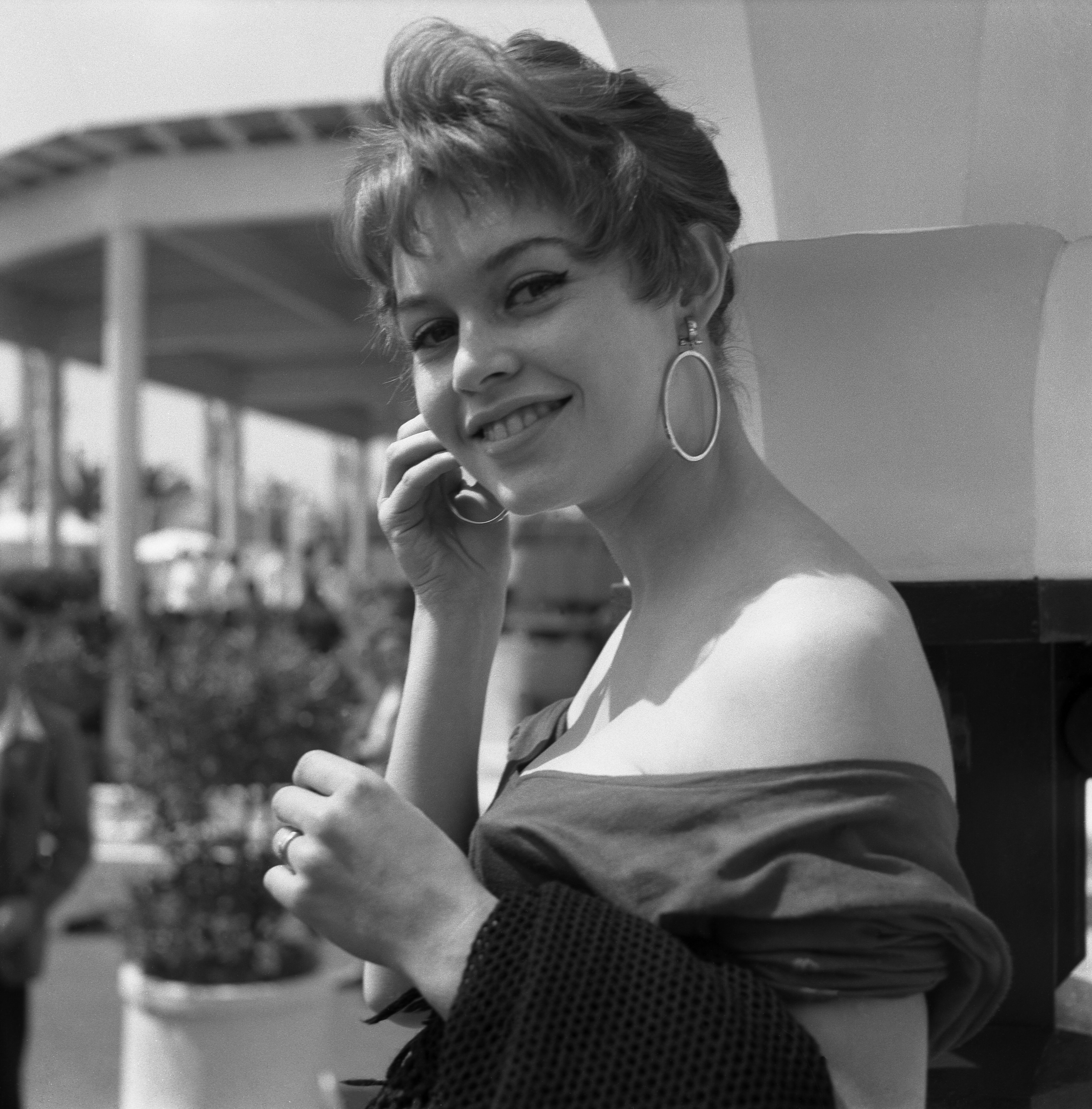 Brigitte Bard portant une chemise nue et de boucles d'oreilles rondes, Cannes, 1955. | Photo : GettyImage