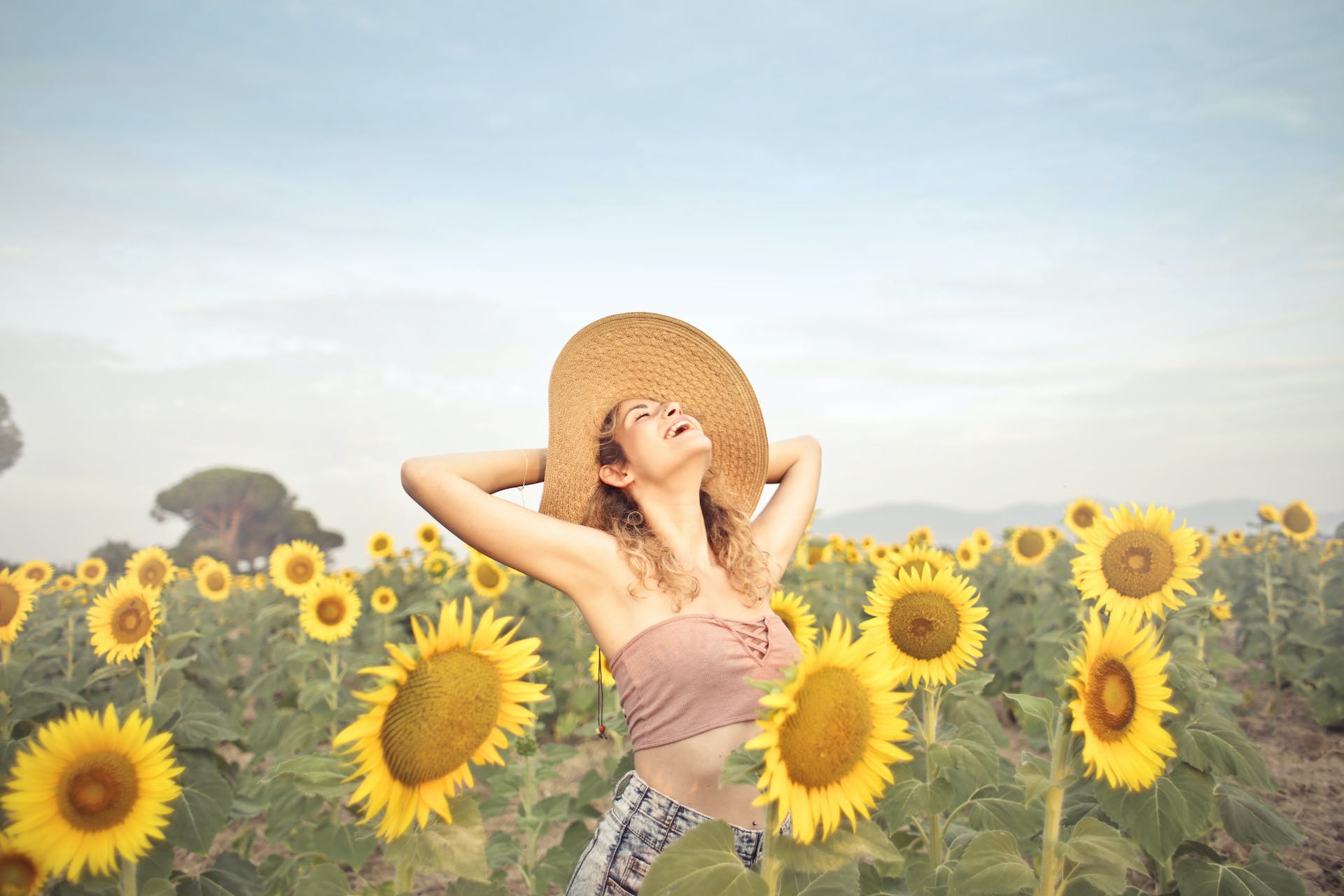 Femme heureuse debout dans un champ de tournesols | Source : Pexels
