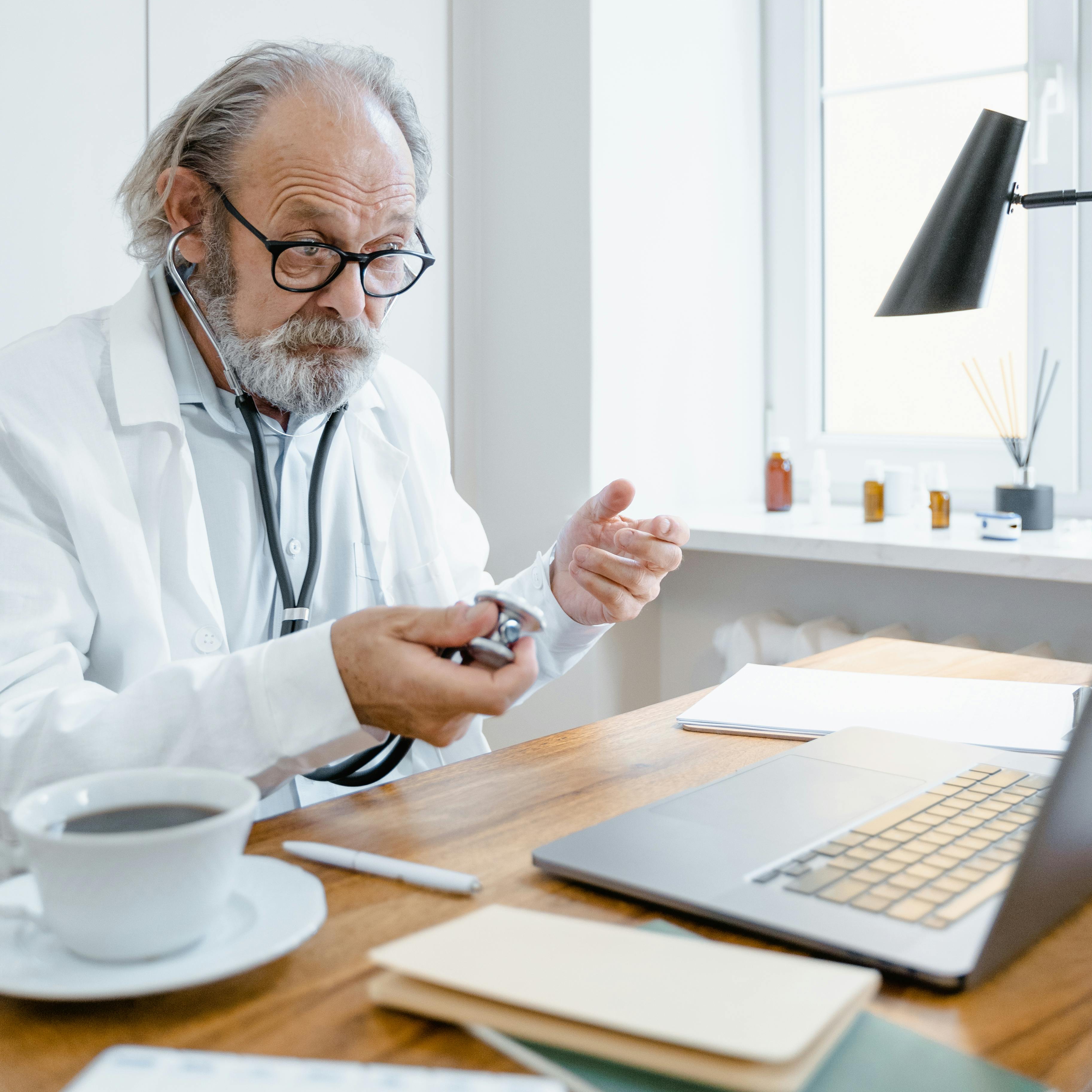 Un médecin derrière son bureau faisant un geste de la main | Source : Pexels