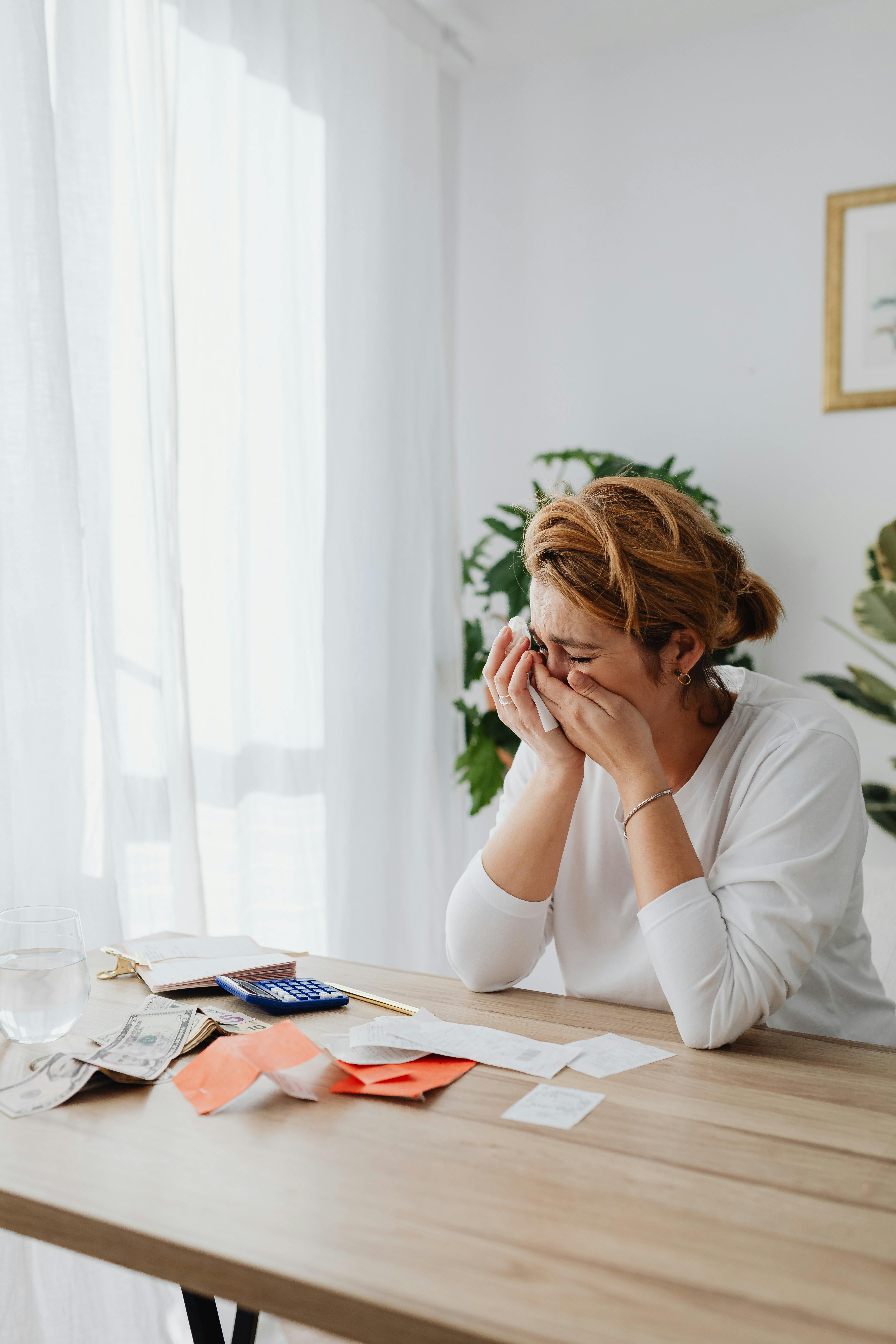 Une femme qui pleure en faisant de la paperasse | Source : Pexels