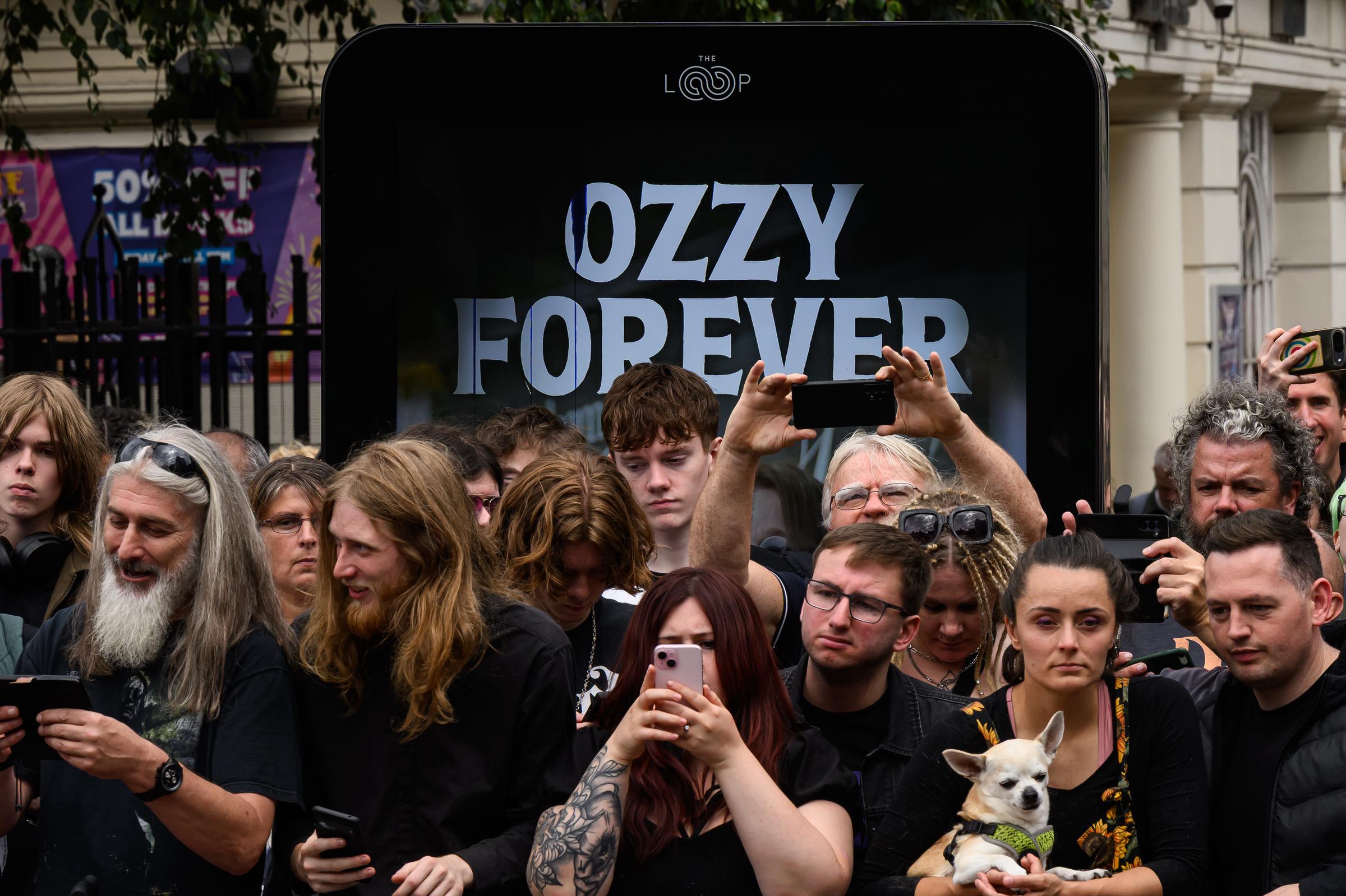 Les fans se rassemblent au pont Black Sabbath après la visite des membres de la famille Osbourne pour voir les hommages rendus à feu Ozzy Osbourne alors que son cortège funèbre traverse sa ville natale de Birmingham, le 30 juillet 2025 à Birmingham, en Angleterre. | Source : Getty Images