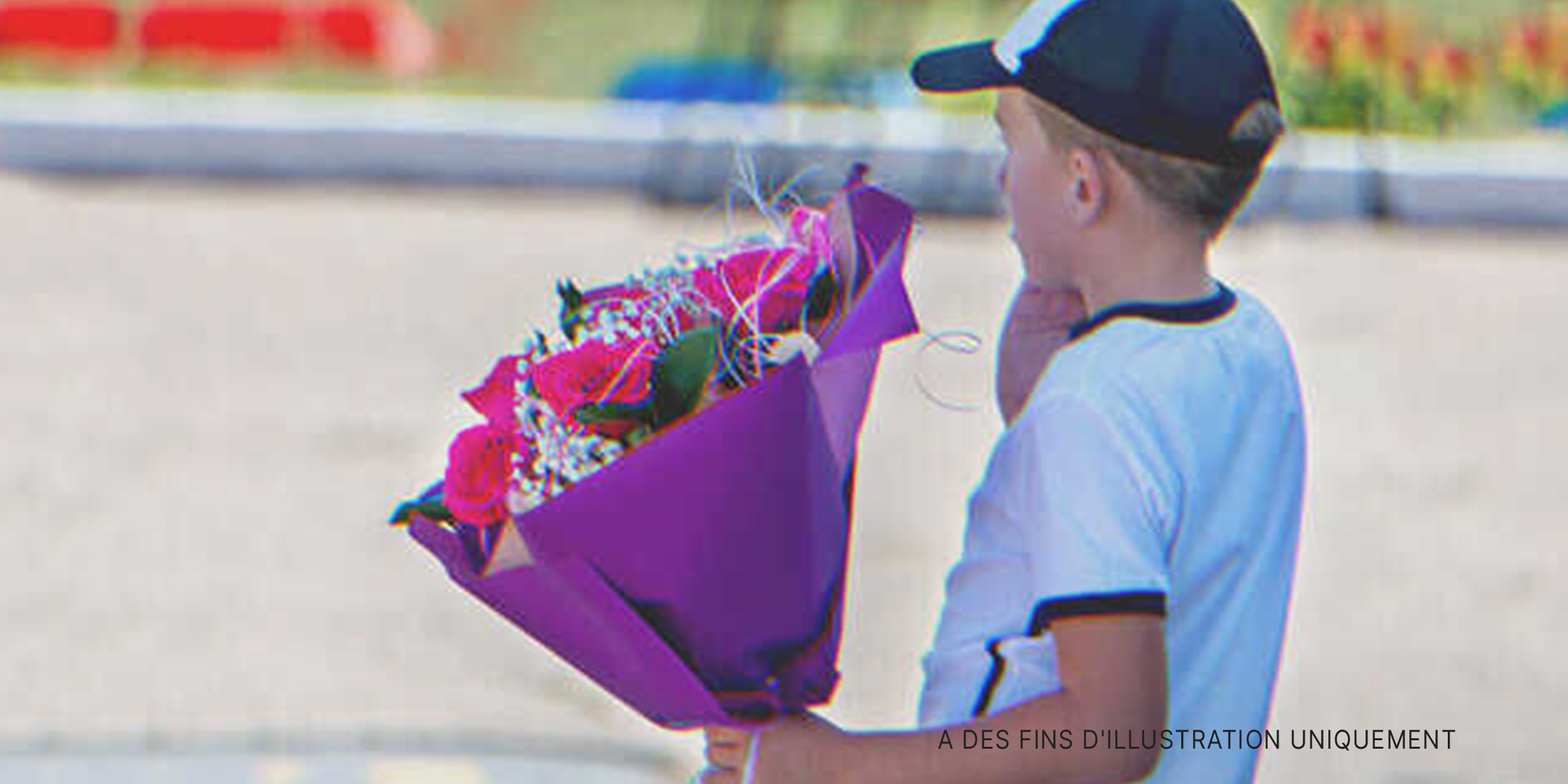 Un petit garçon tenant un bouquet de fleurs | Source : Shutterstock