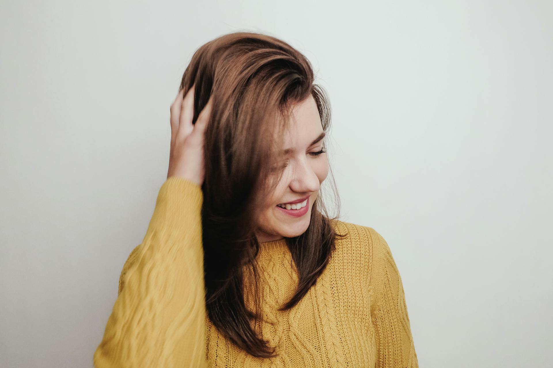 Une femme ébouriffant ses cheveux et souriant | Source : Pexels