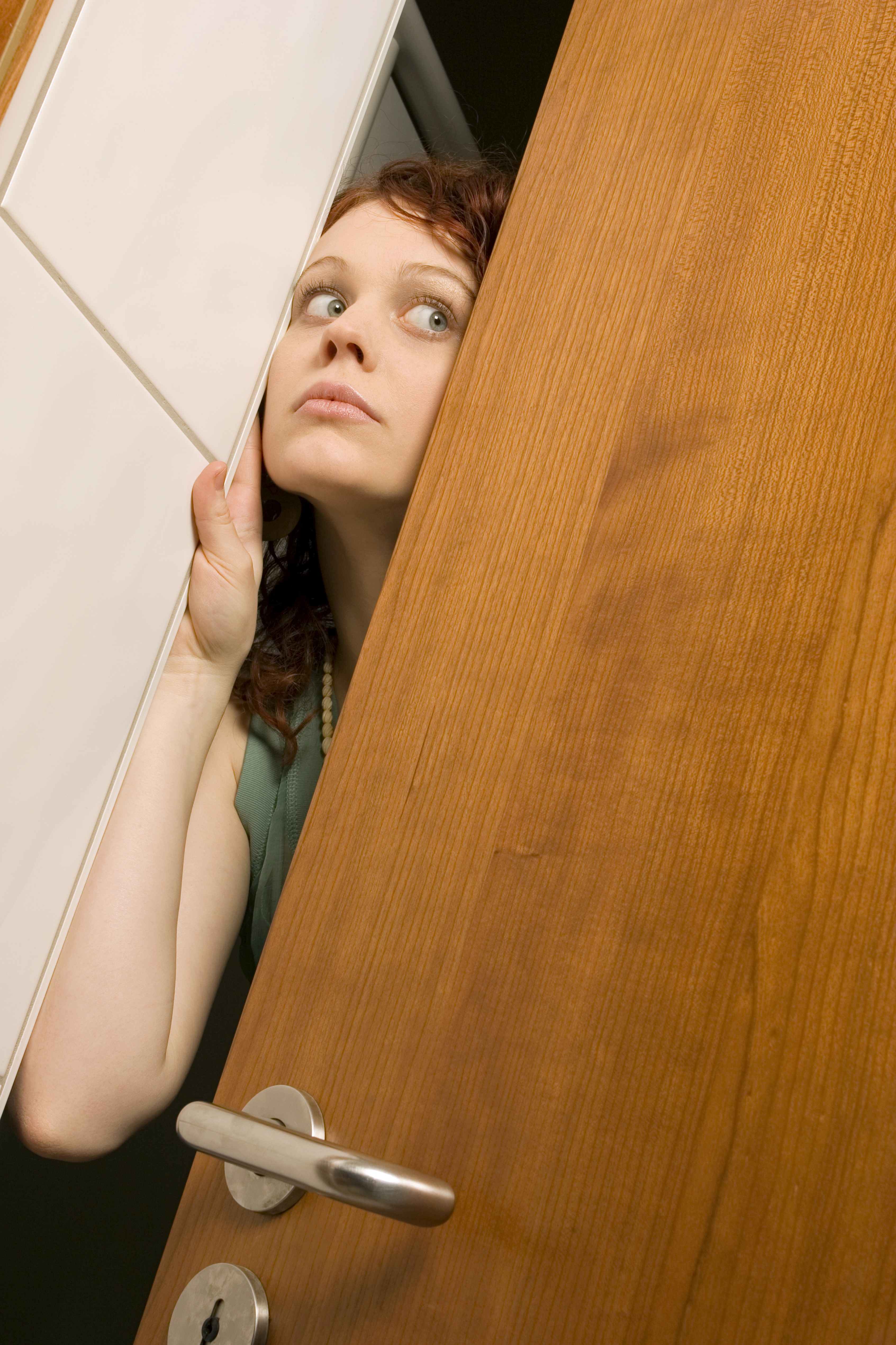 Femme jetant un coup d'œil à travers une porte | Source : Getty Images
