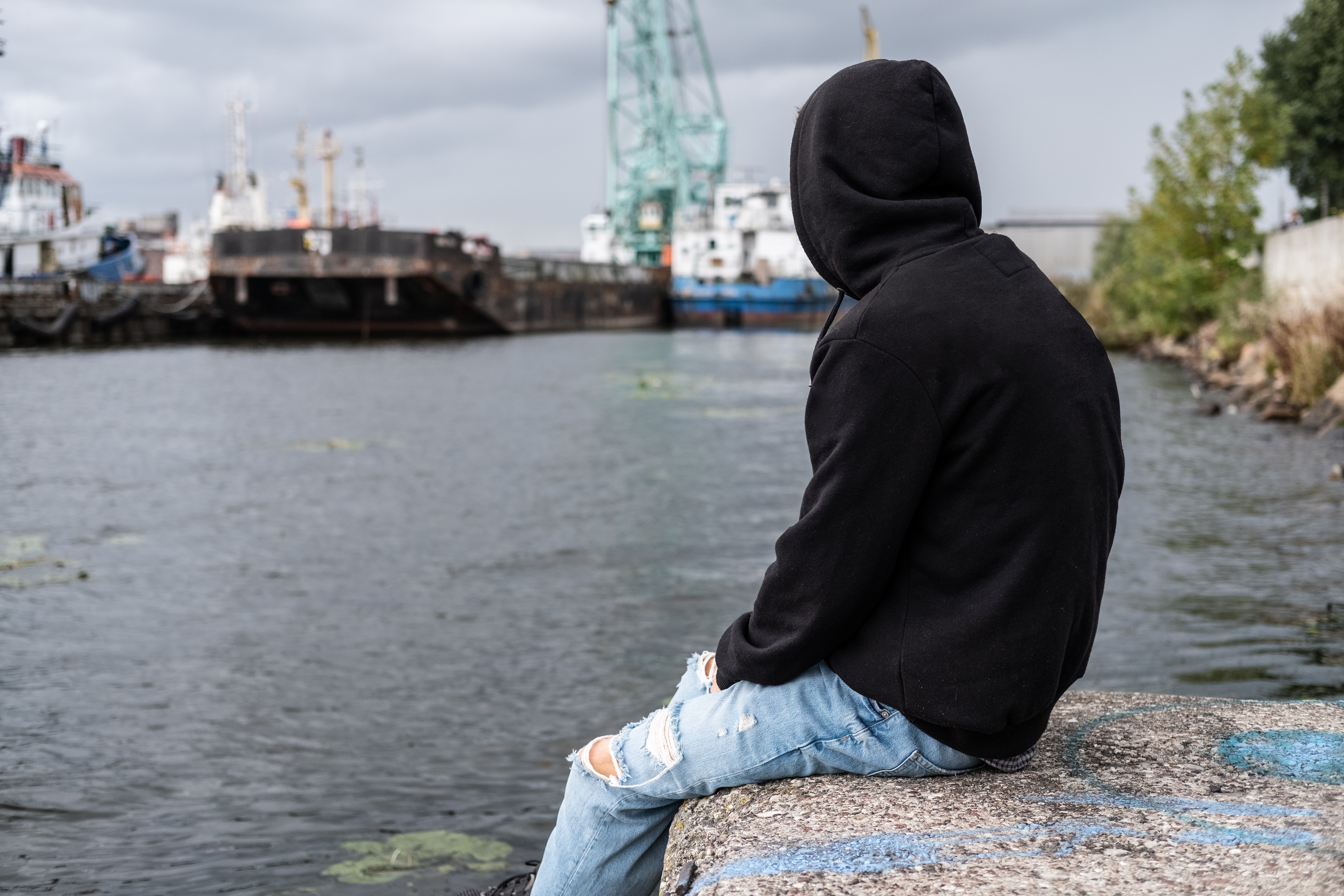 Un garçon au bord de la rivière se sentant seul | Source : Shutterstock
