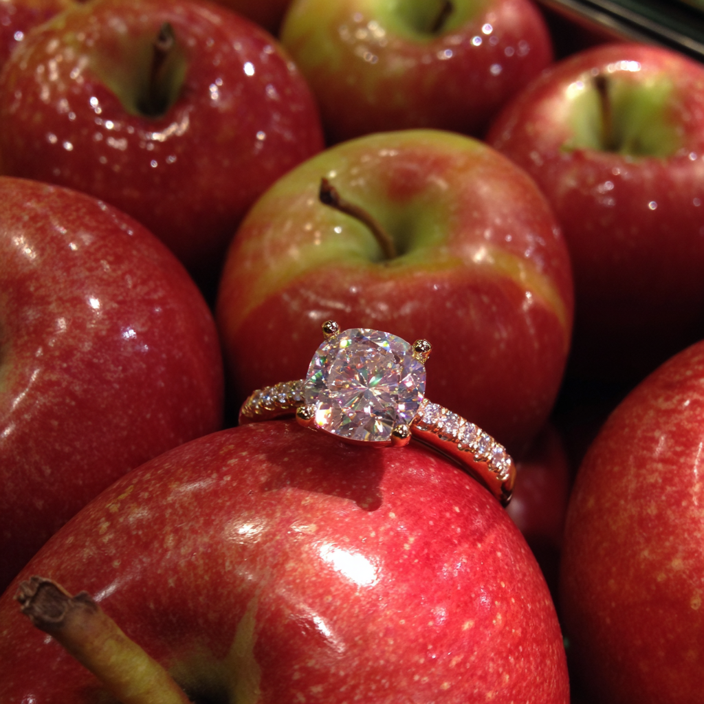 Une bague en diamant dans un présentoir de pommes | Source : Midjourney
