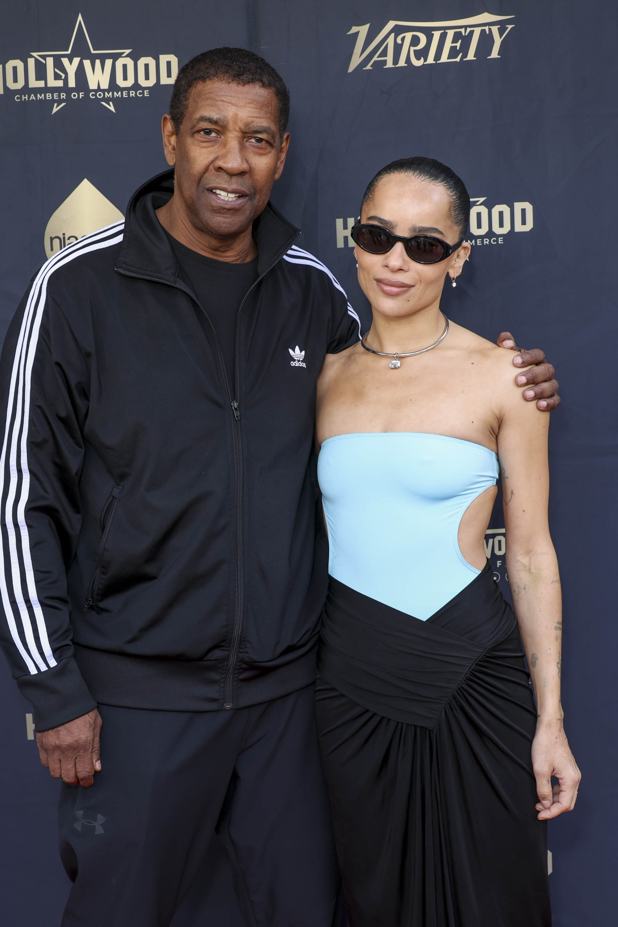 Posant aux côtés de Zoë Kravitz lors de la cérémonie d'intronisation de Lenny Kravitz au Hollywood Walk of Fame, Denzel Washington porte un survêtement Adidas sportif et un t-shirt foncé. Sa coupe de cheveux courte allie confort décontracté et style emblématique.