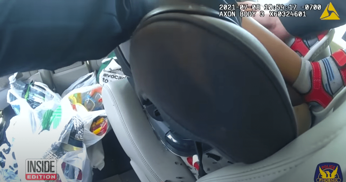 Capture d'écran d'un officier sortant un bébé d'un véhicule chaud. | Source : YouTube/ Inside Edition