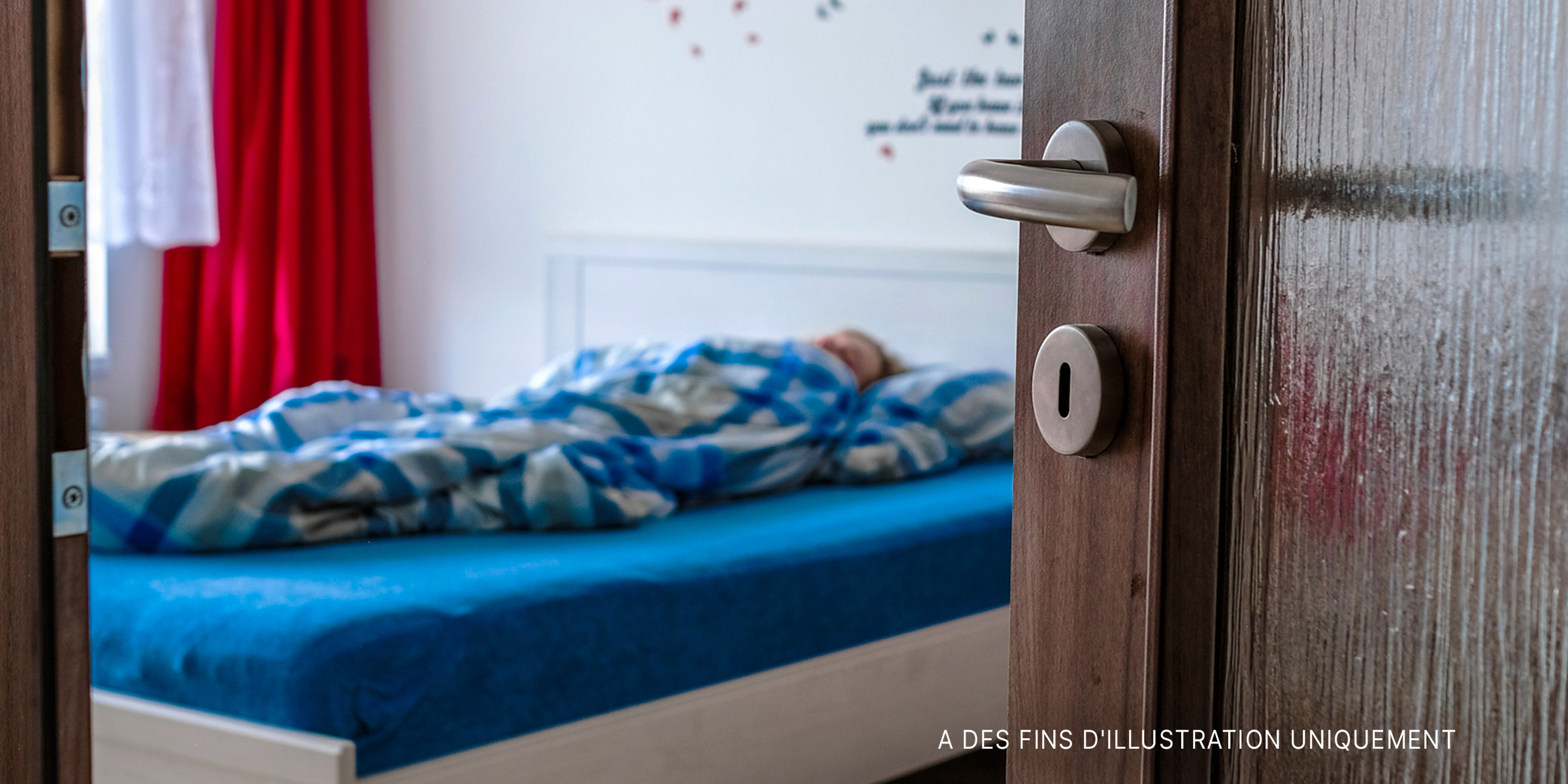 Une femme allongée dans son lit laissant la porte ouverte | Source : Shutterstock