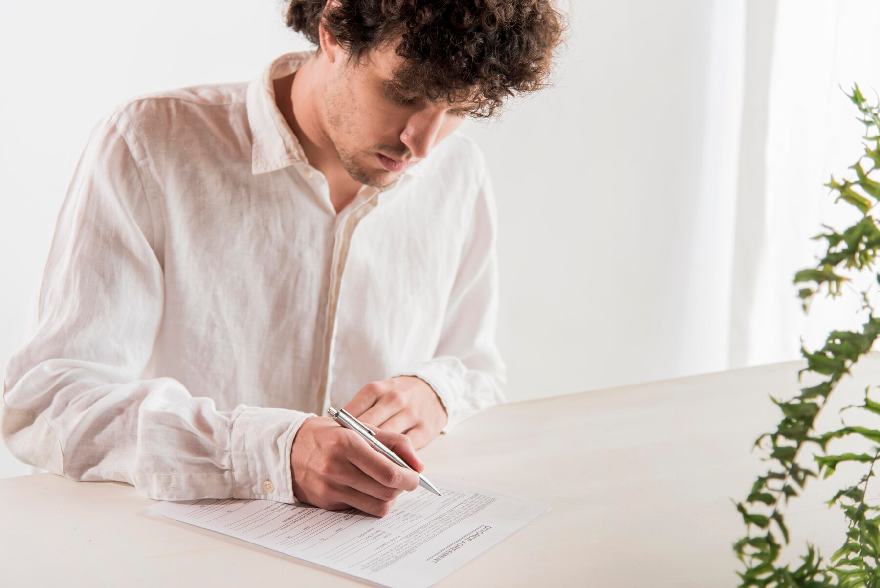 Un homme signant un document | Source : Freepik