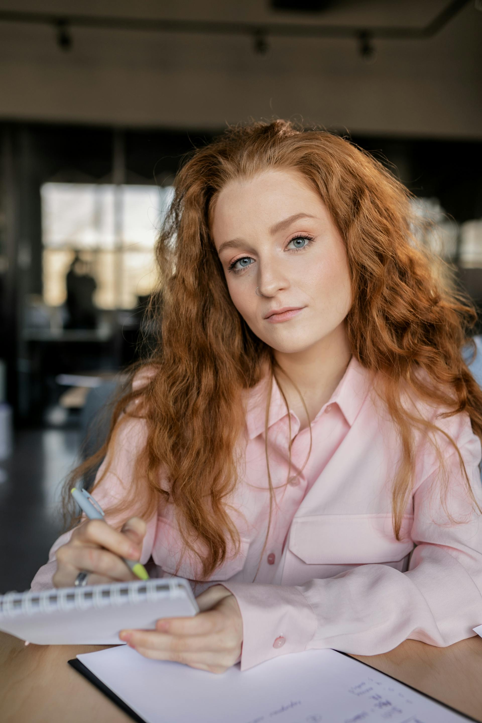 Une femme tenant un stylo et un cahier | Source : Pexels