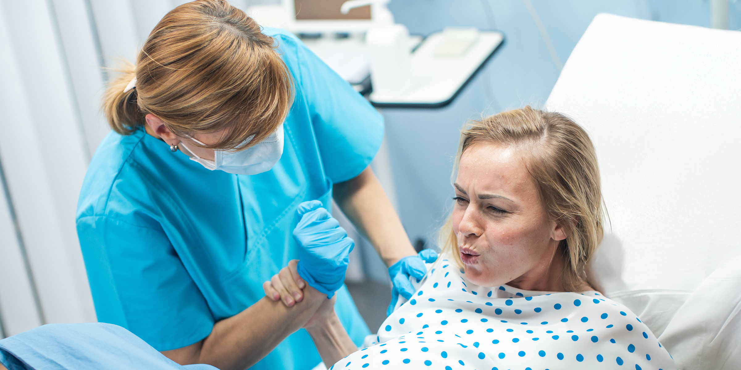 Une femme tenant la main d'une infirmière dans une chambre d'hôpital | Source : Shutterstock