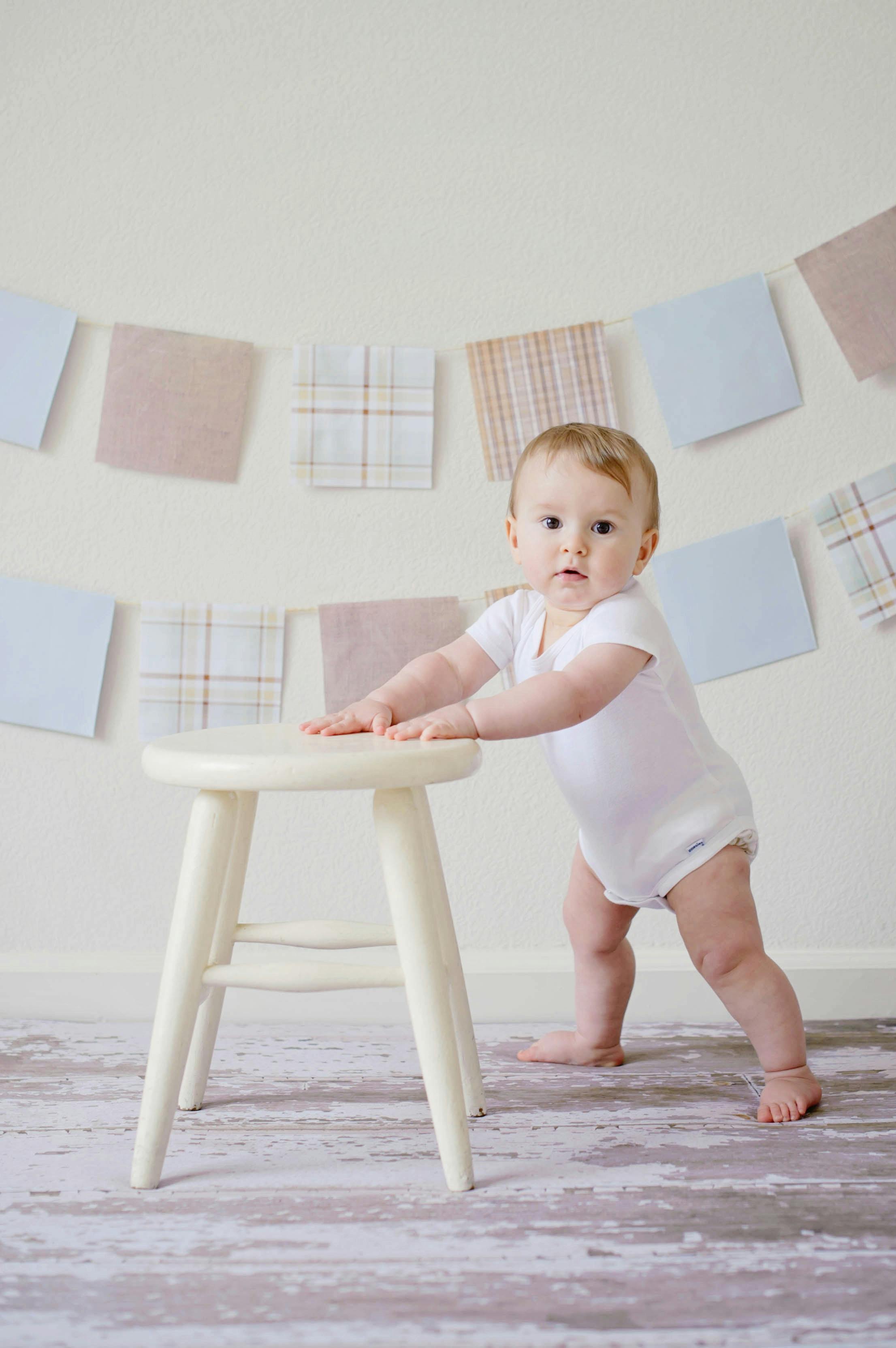 Un bébé qui apprend à se tenir debout à l'aide d'un tabouret | Source : Pexels