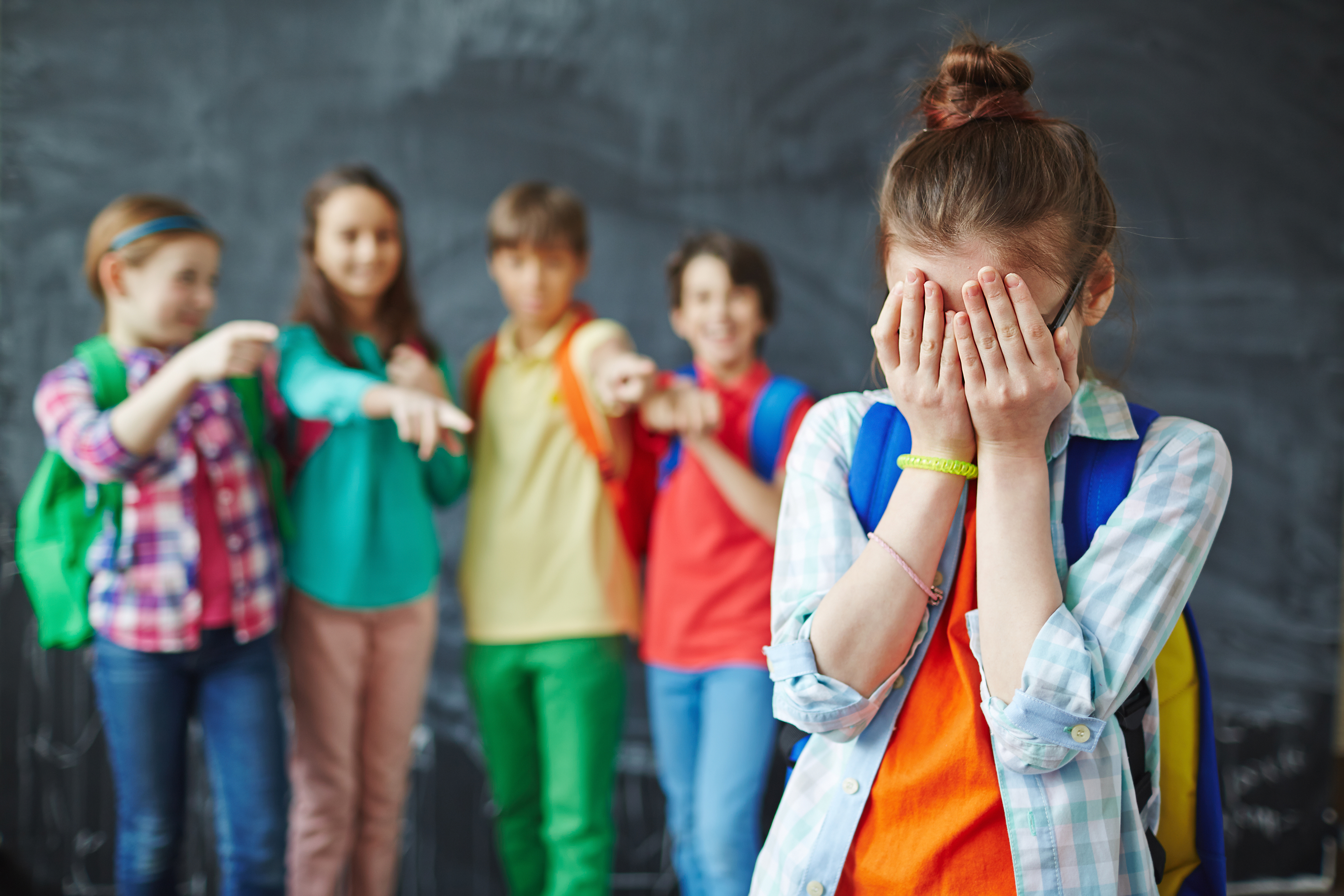 Un groupe de gamins tyrans et une fille qui pleure | Source : Shutterstock