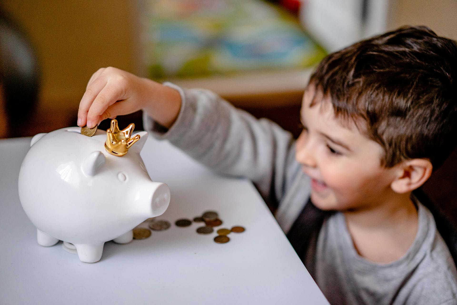 Un petit garçon qui met des pièces dans une tirelire | Source : Pexels