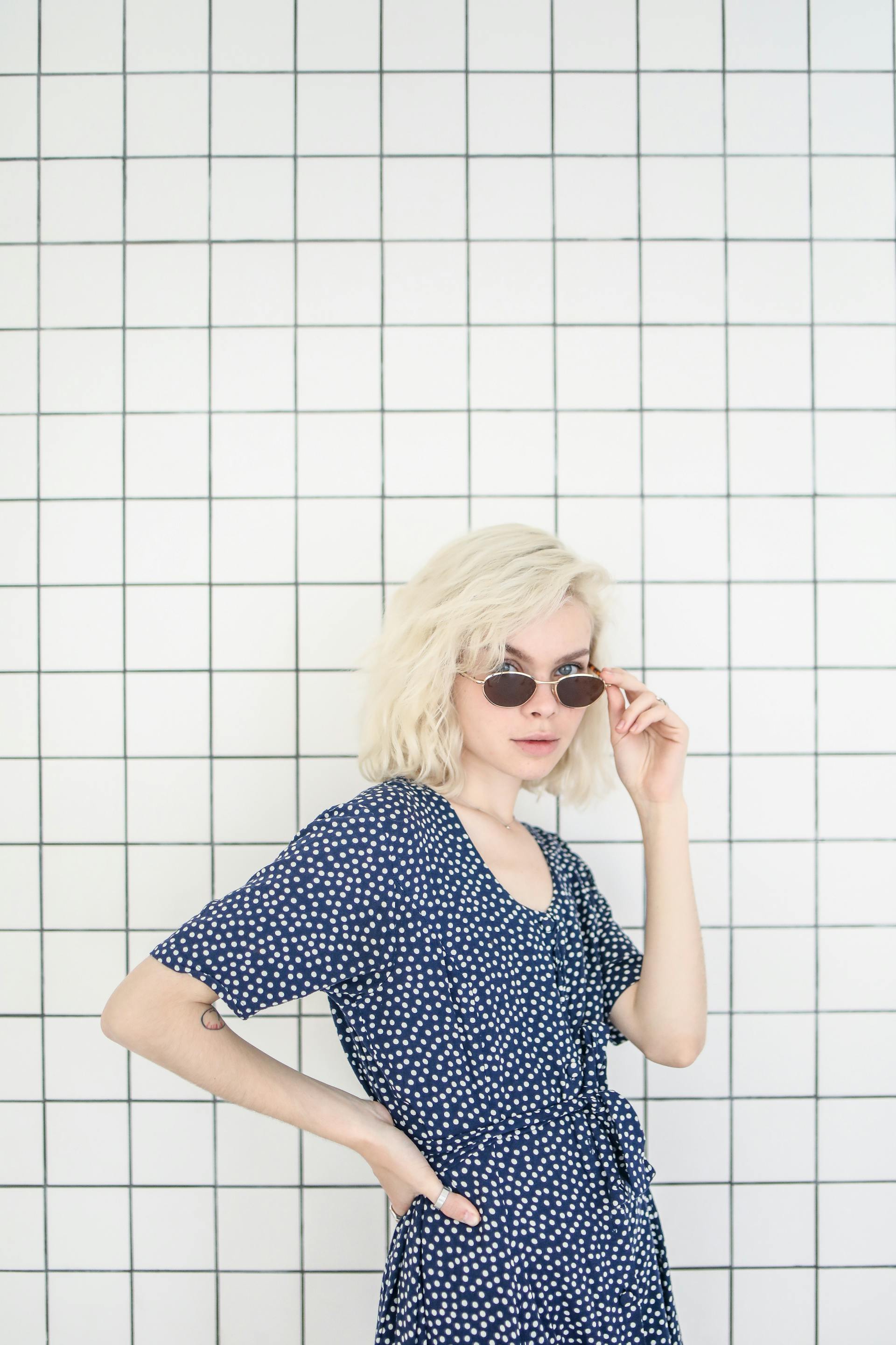 Une femme qui regarde par-dessus le haut de ses lunettes de soleil | Source : Pexels