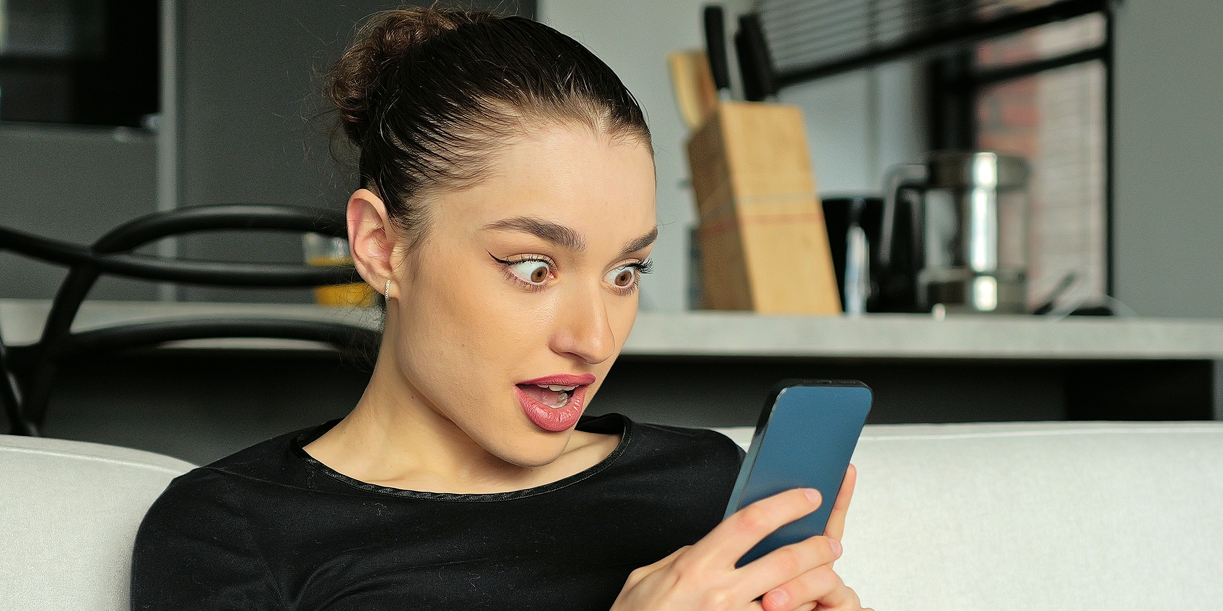 Une femme choquée qui regarde son téléphone | Source : Shutterstock