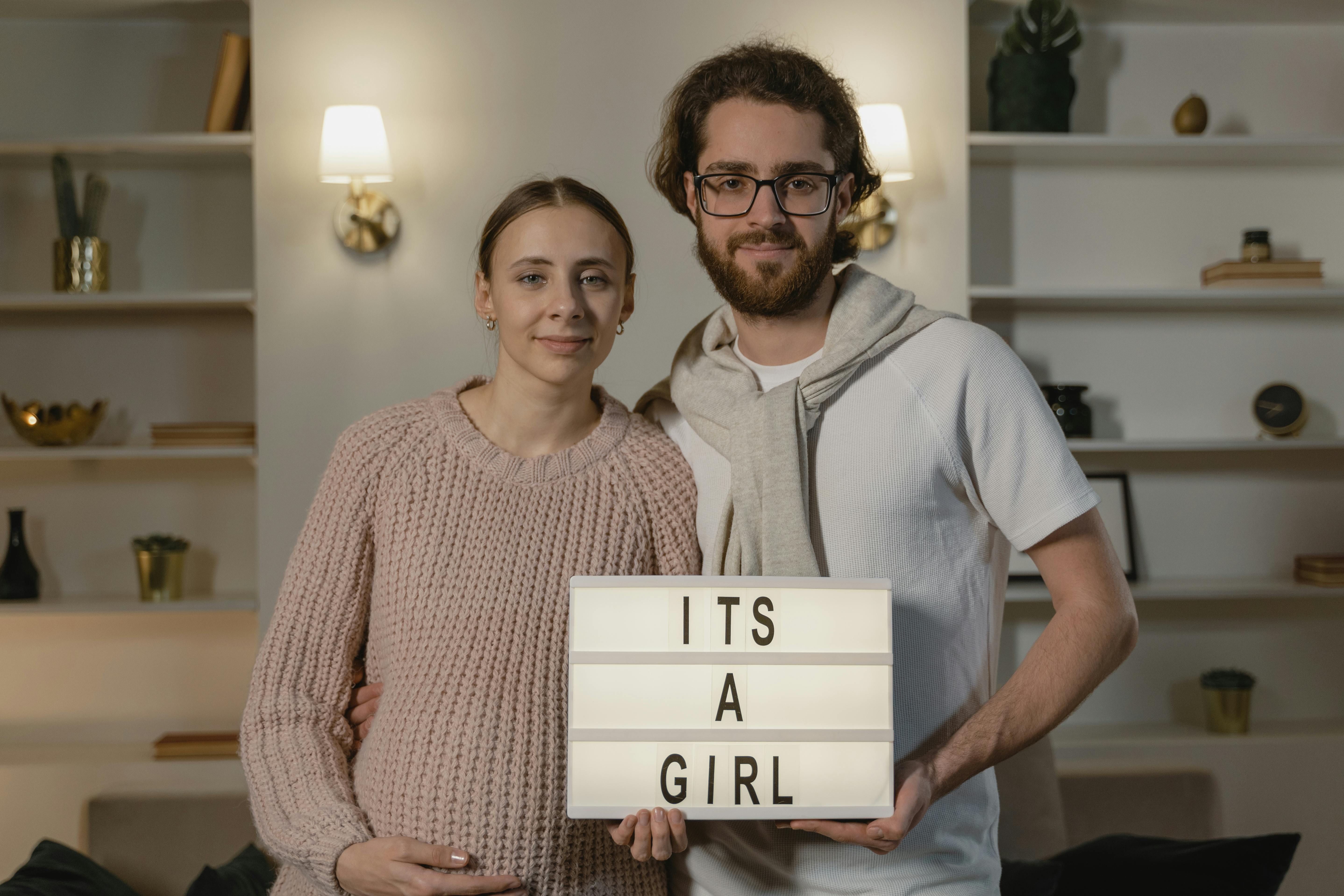 Un couple tenant une planche à lettres avec un message | Source : Pexels
