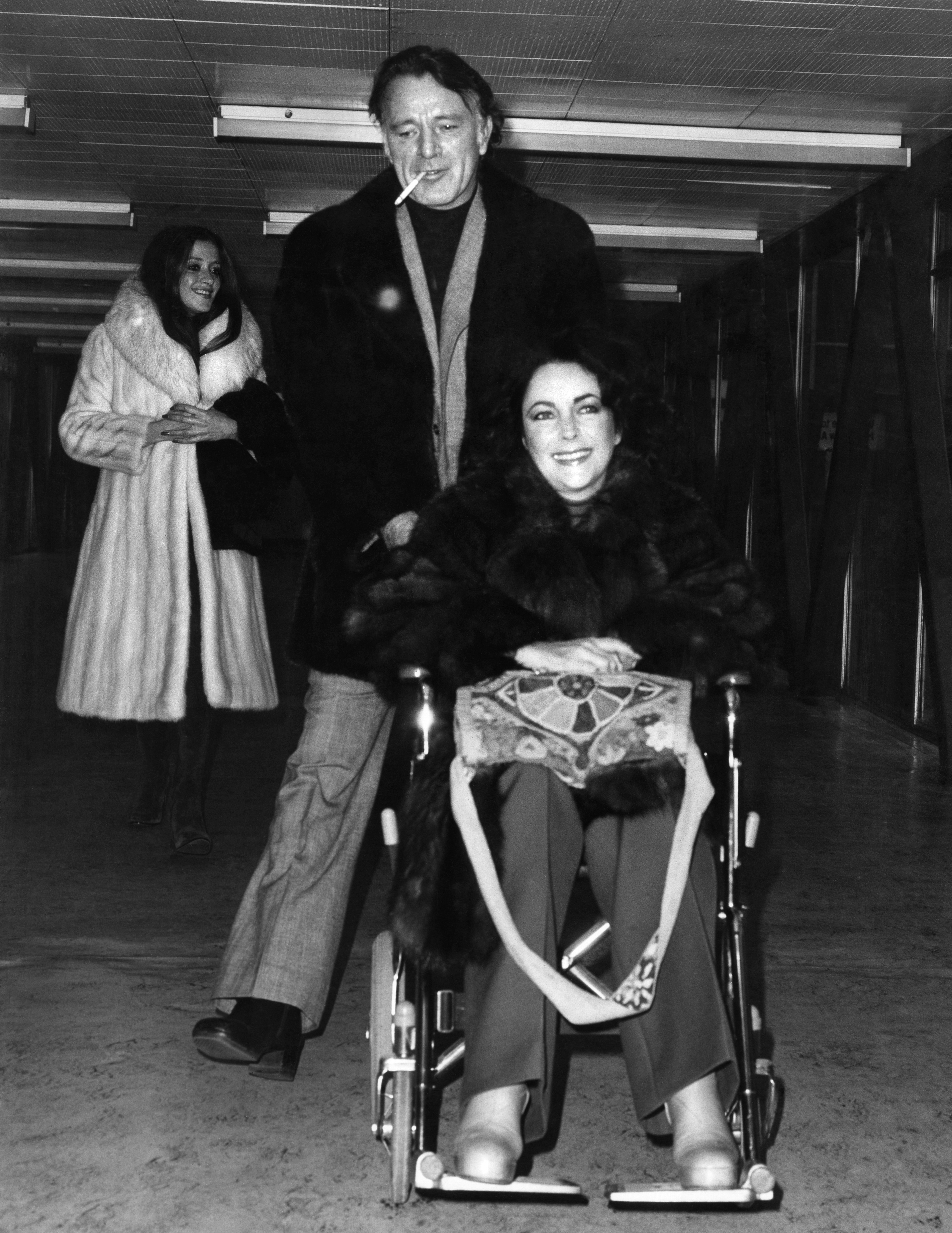 Elizabeth Taylor et son cinquième et sixième mari, Richard Burton, photographiés le 23 décembre 1975 à l'aéroport d'Heathrow | Source : Getty Images