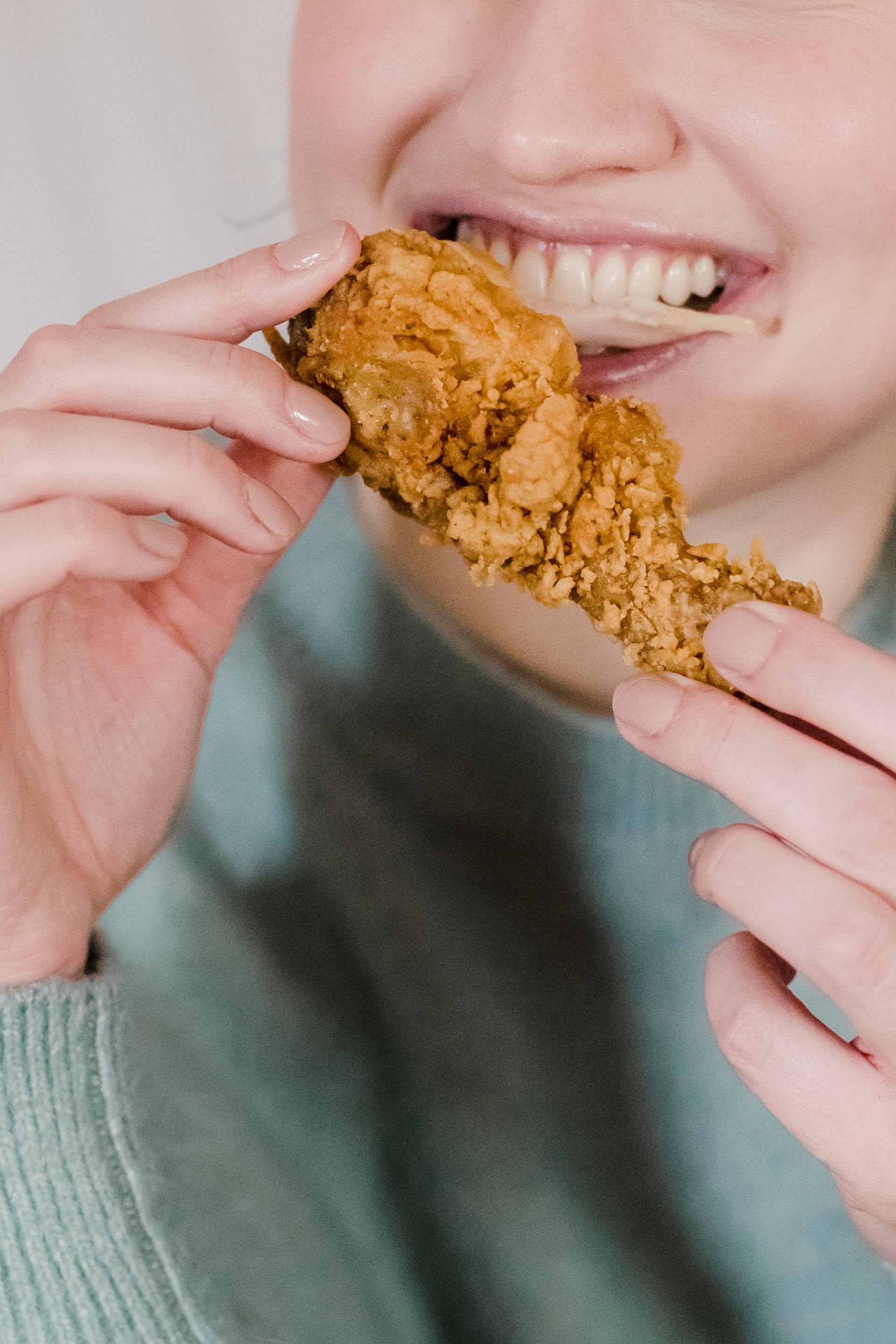 Une personne mangeant du poulet frit | Source : Pexels