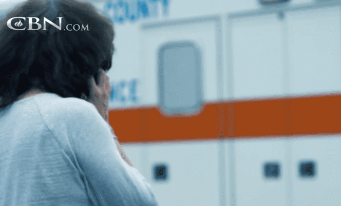 Pam debout près d'une ambulance. | Source : Youtube.com/The 700 Club