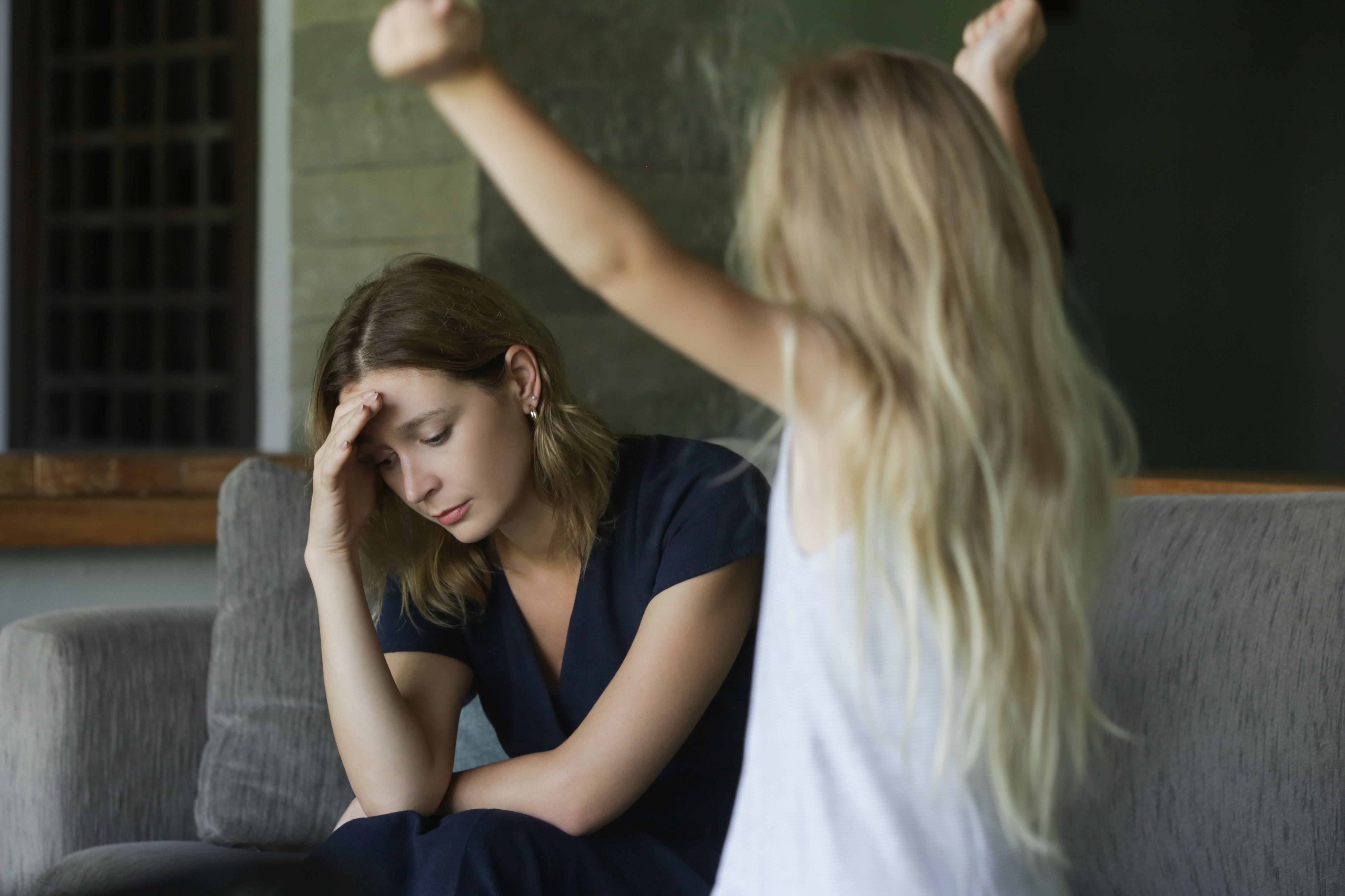 Une jeune fille qui pique une colère devant sa maman fatiguée | Source : Shutterstock