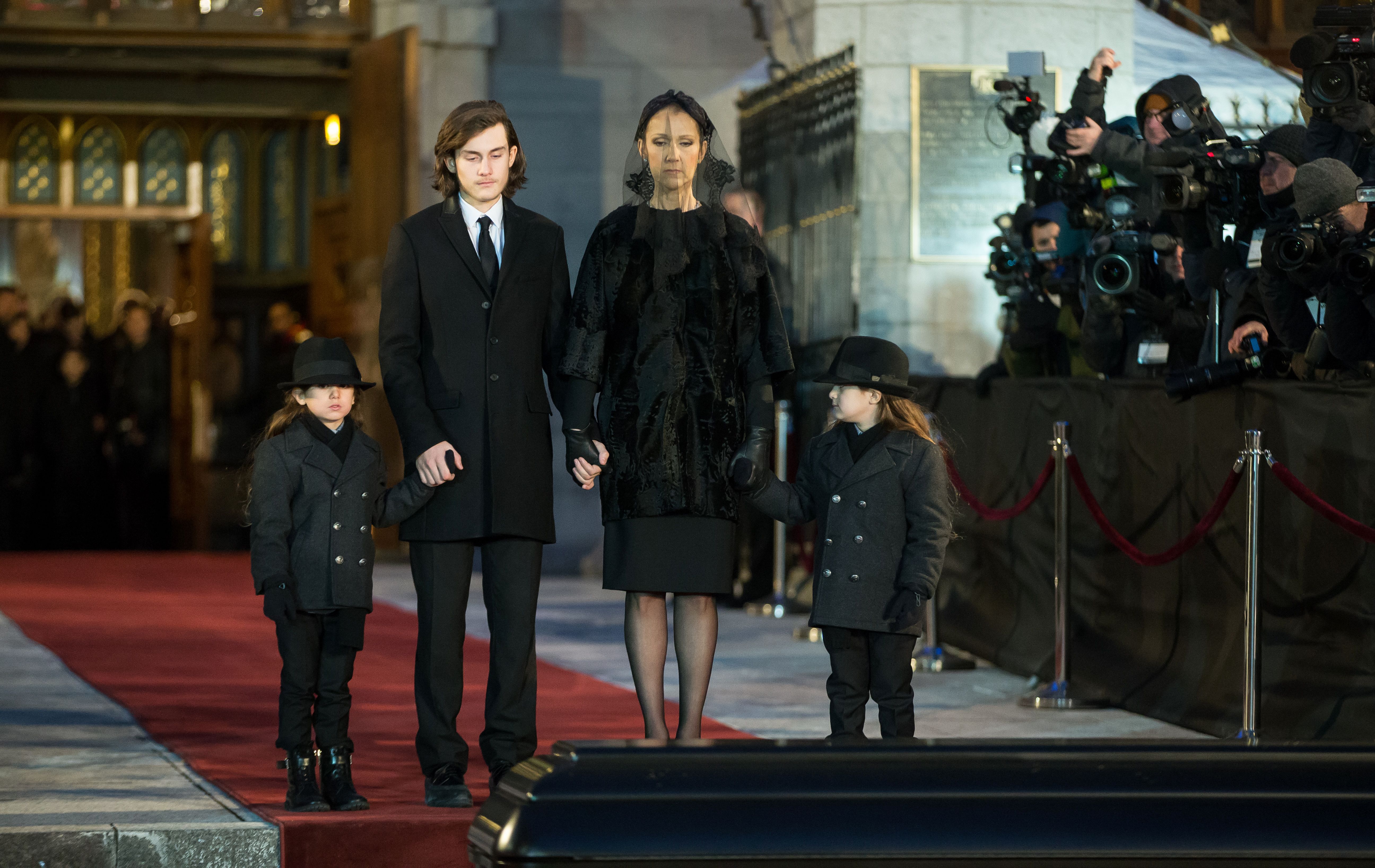 Céline Dion et ses fils René-Charle, Eddy et Nelson, font une pause pour voir le cercueil de René Angélil après son service funéraire à Montréal, au Québec, le 22 janvier 2016. | Source : Getty Images