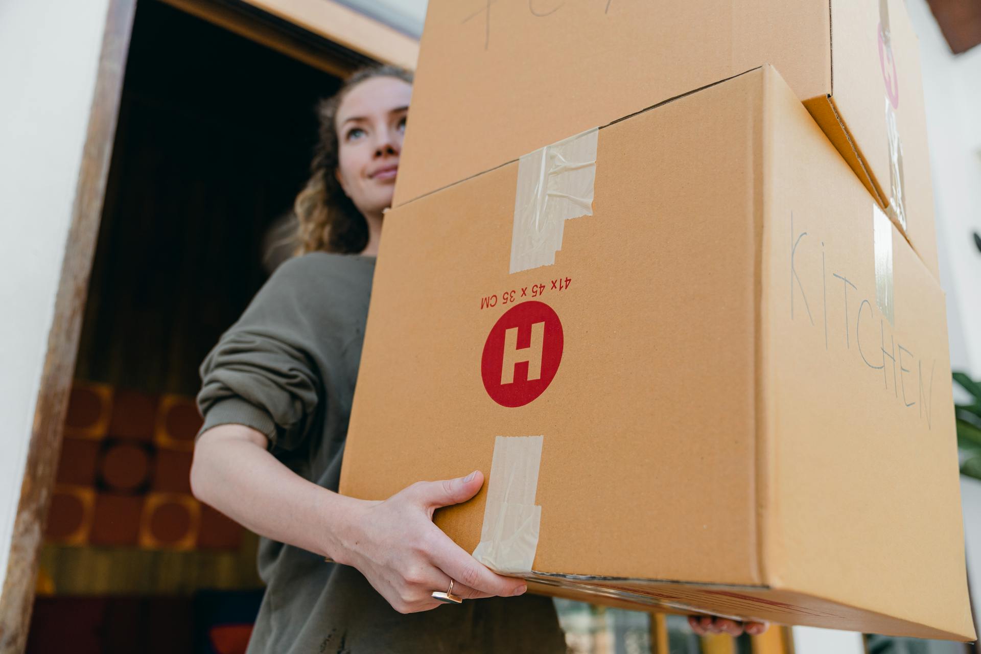 Une jeune femme transportant des boîtes en carton | Source : Pexels