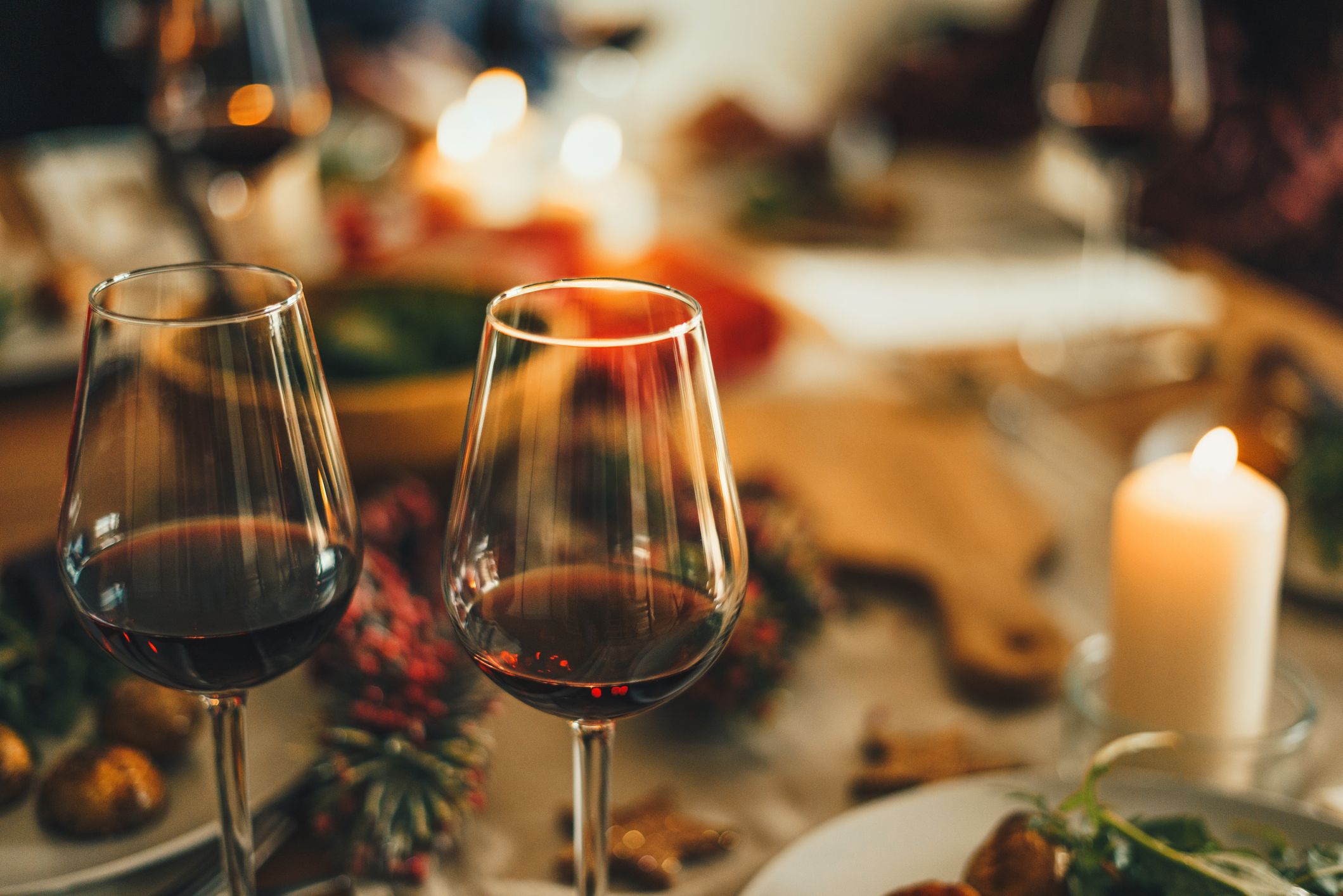 Deux verres à vin dans un décor de dîner éclairé à la bougie. | Source : Getty Images