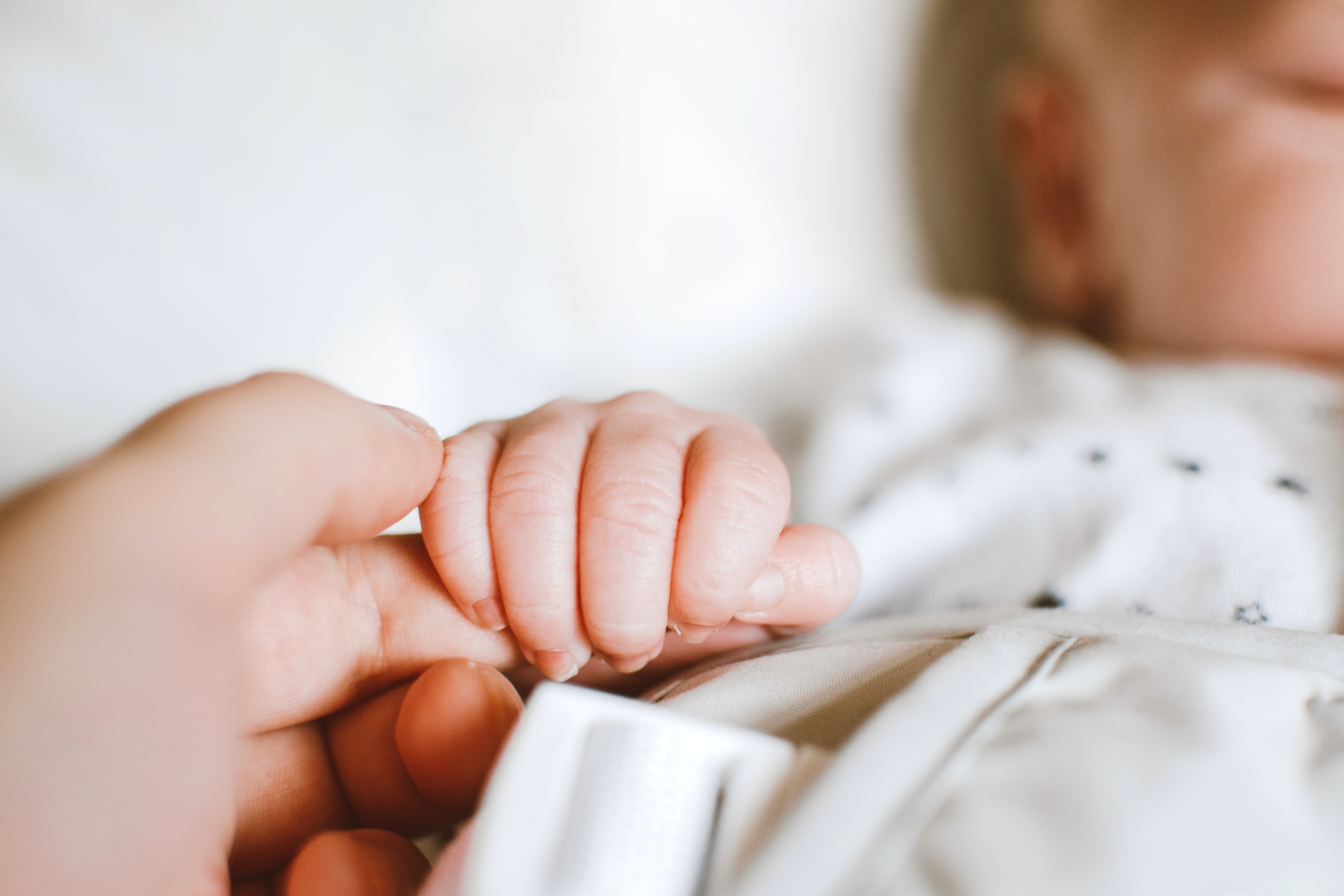 La main d'un bébé serrant le doigt d'une femme | Source : Pexels