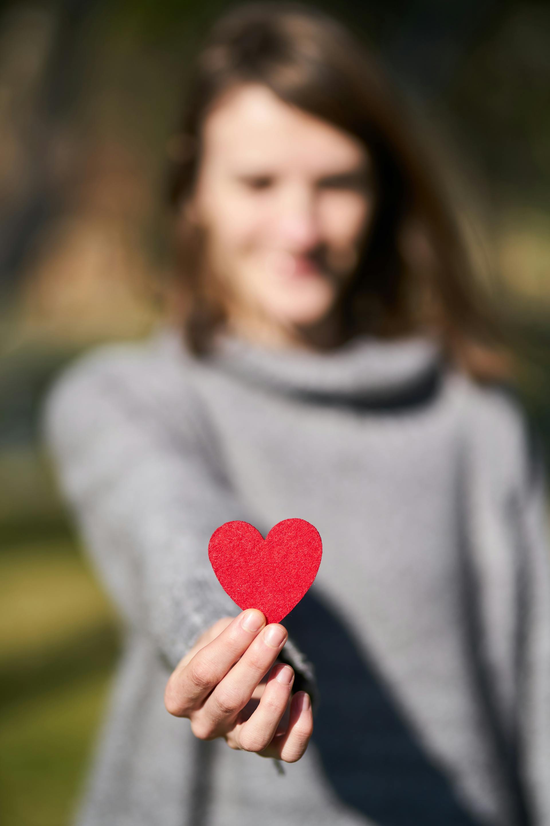 Une femme tenant un découpage en forme de cœur | Source : Pexels