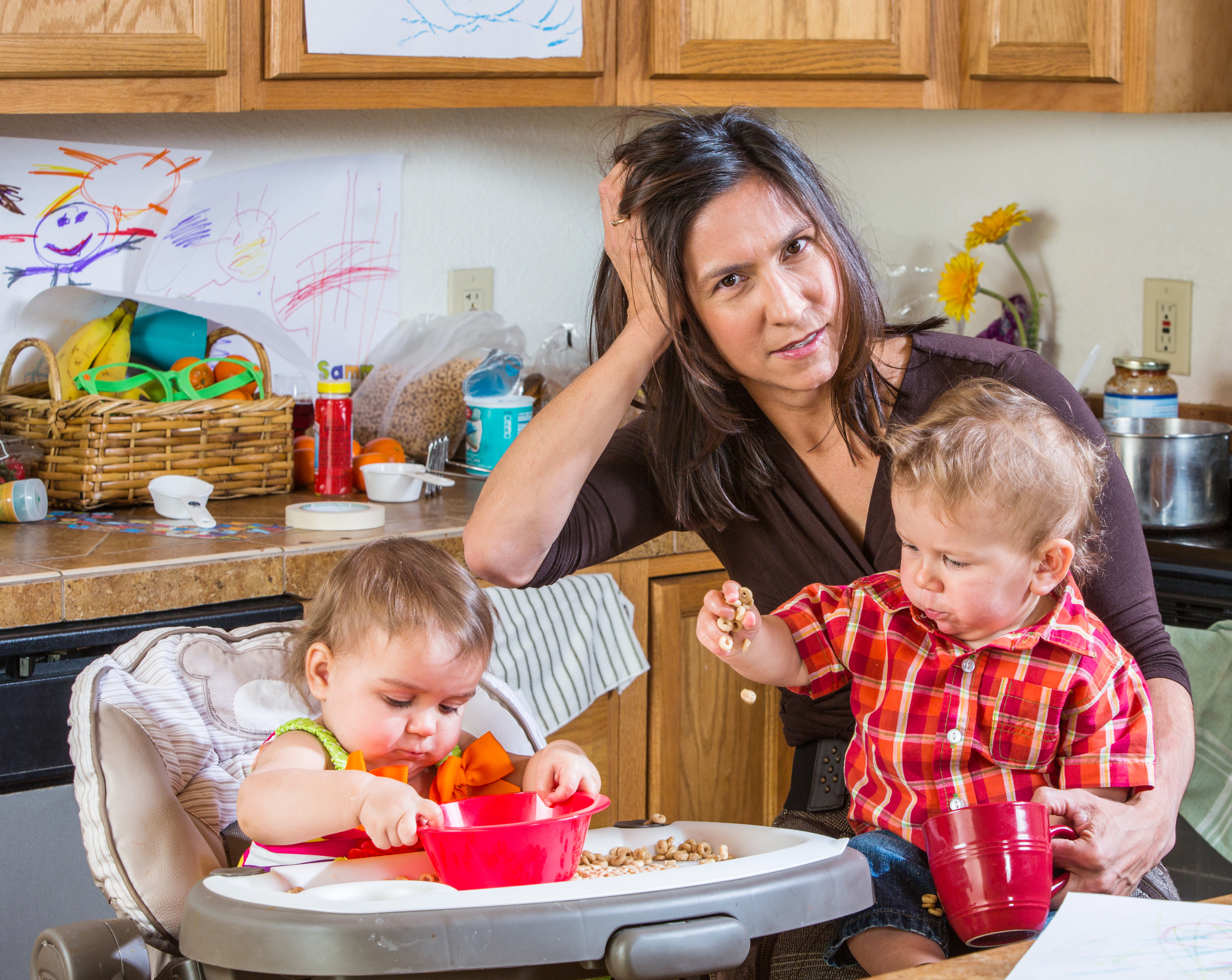 Une mère stressée dans la cuisine avec ses bébés | Source : Shutterstock