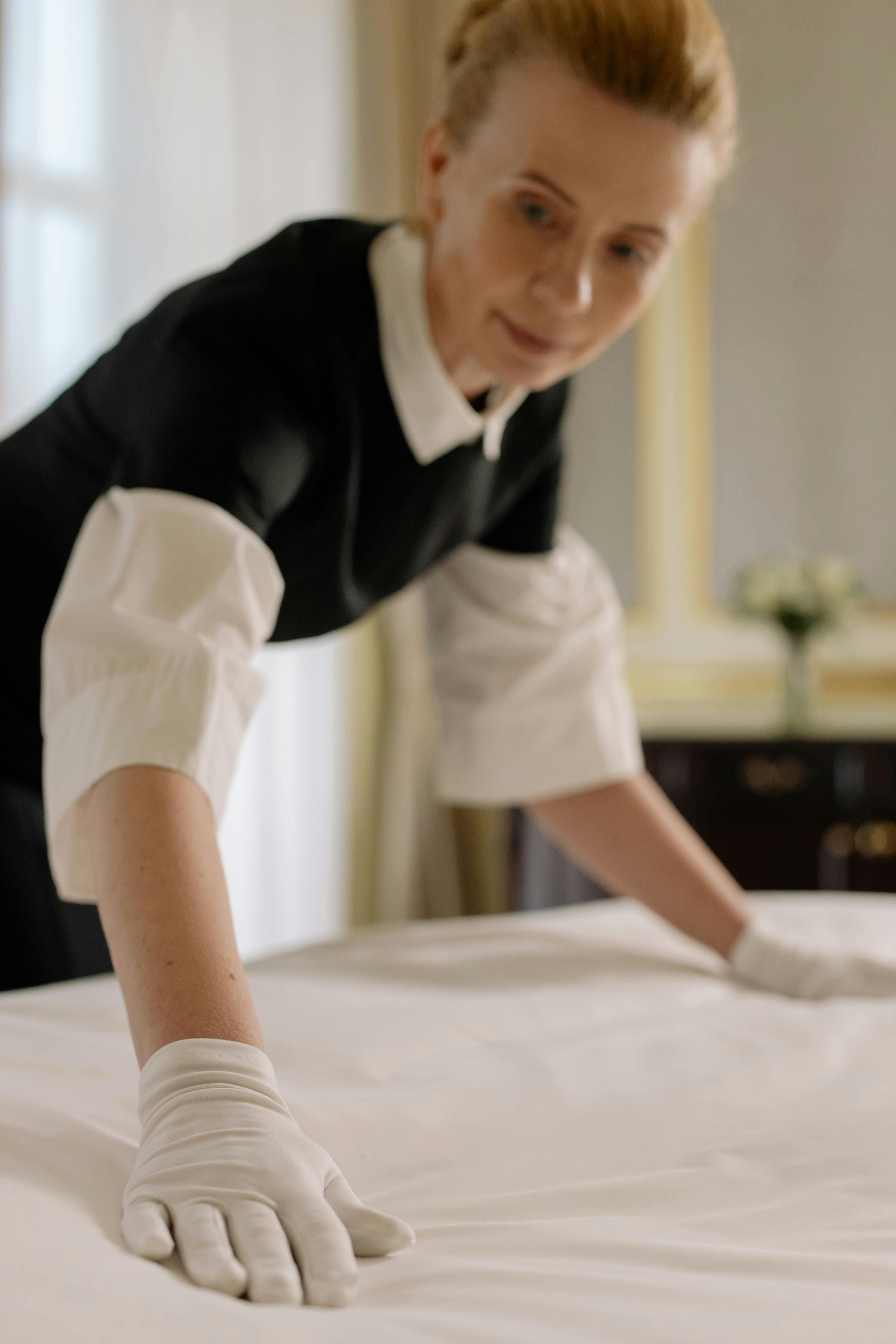 Femme en train de ranger une chambre d'hôtel | Source : Pexels