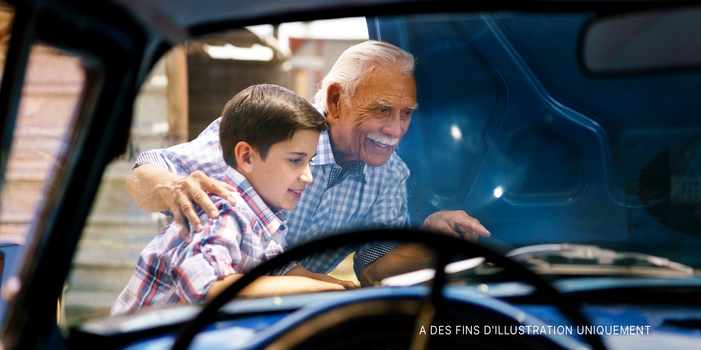 Un vieil homme et son petit-fils travaillant sur une voiture | Source : Shutterstock
