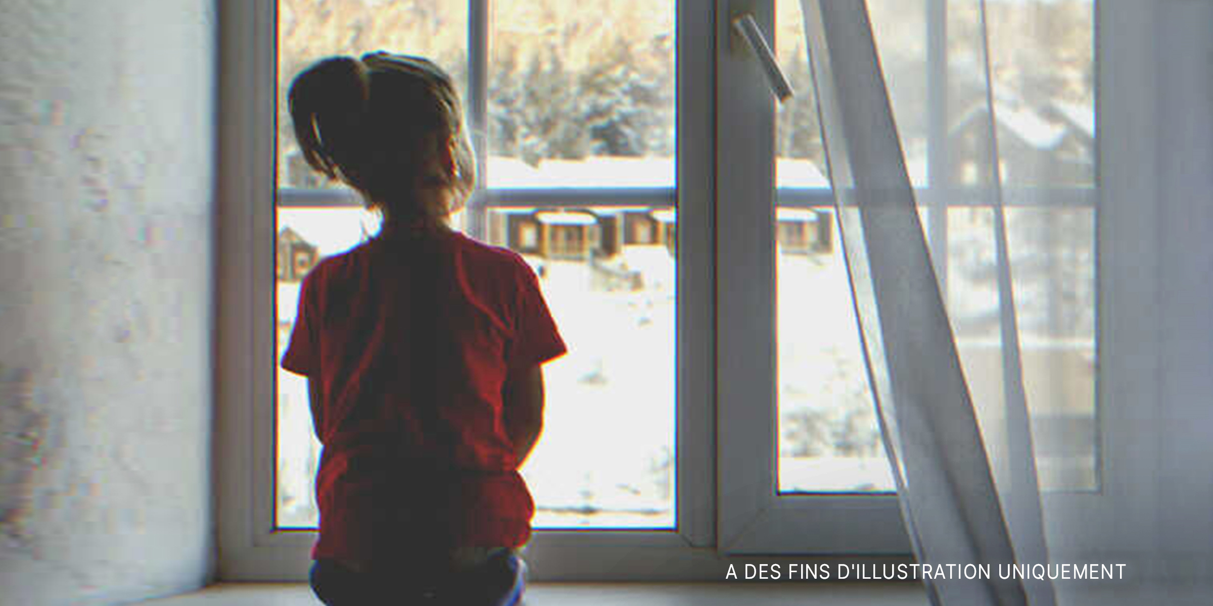 Une fille qui regarde par la fenêtre. | Source : Shutterstock