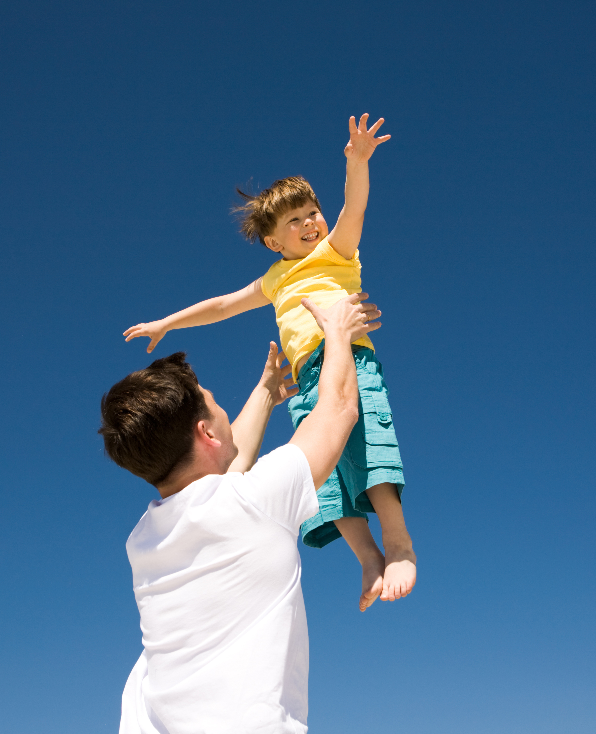 Un homme jouant avec un petit garçon à l'extérieur | Source : Shutterstock