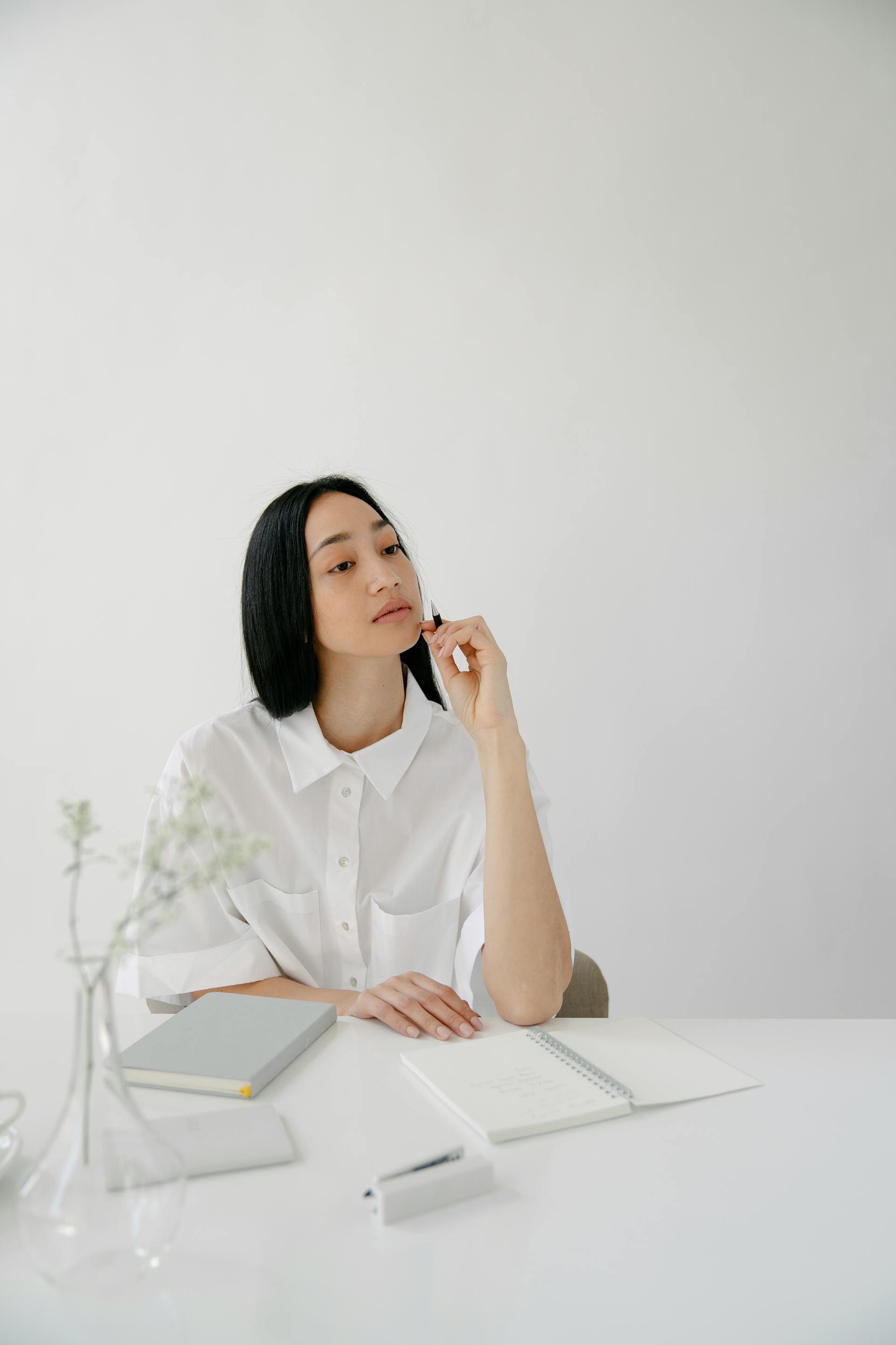 Une femme assise à un bureau qui regarde de haut | Source : Pexels