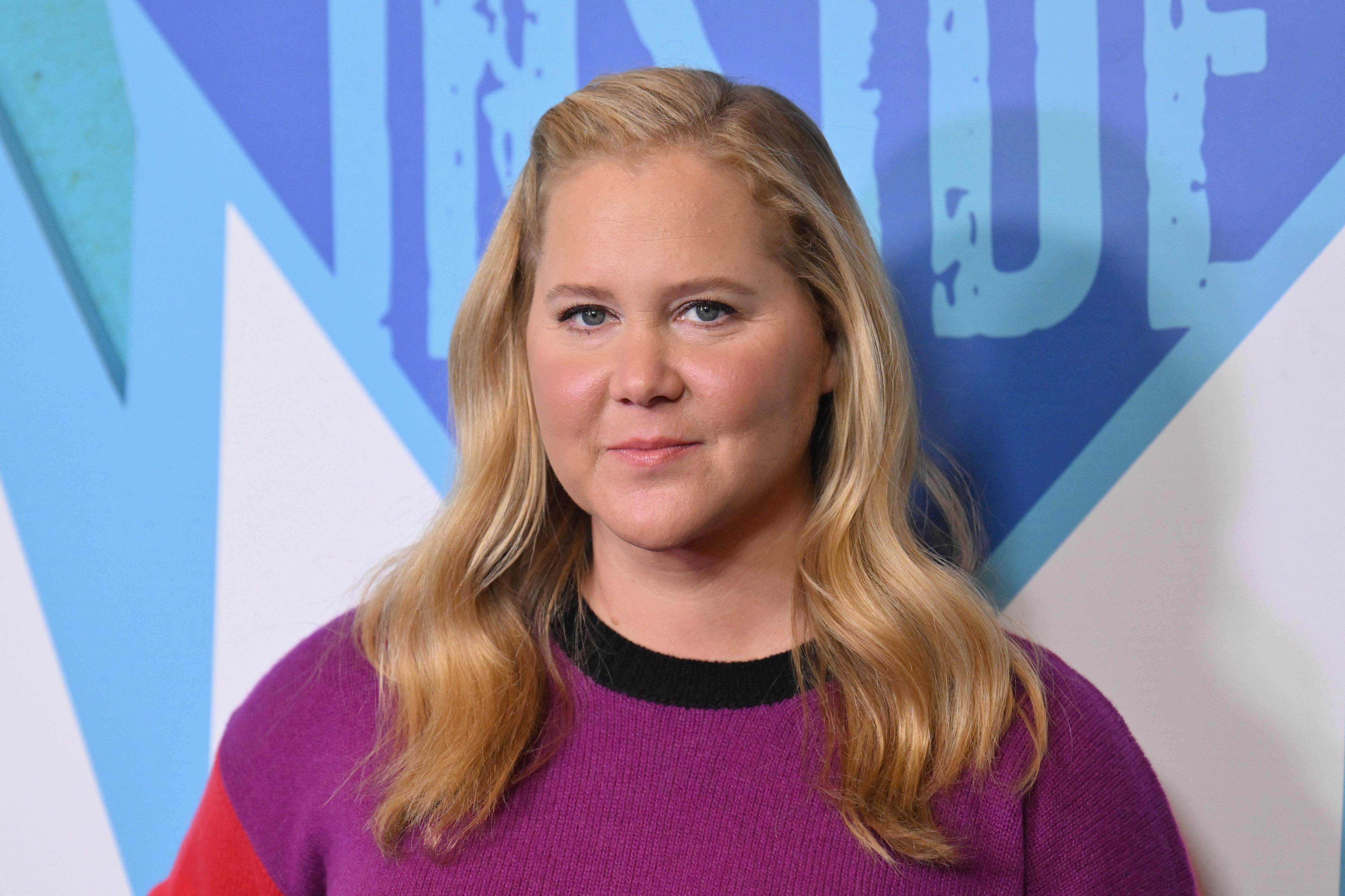 Amy Schumer à la première de la saison 5 de « Inside Amy Schumer » à New York, vêtue d'un pull aux couleurs audacieuses et coiffée de douces ondulations, le 18 octobre 2022.